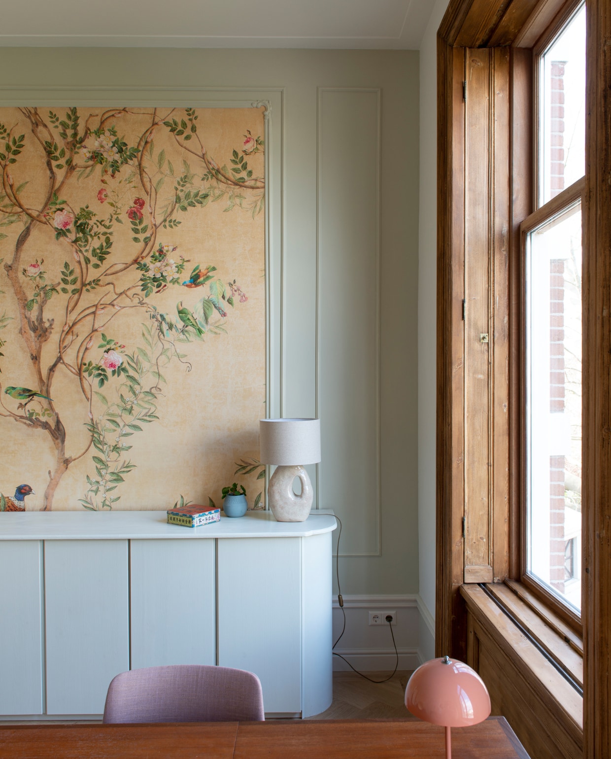 Verfkleur Green Stone van Little Greene. Behang Photowall.se. Kast zelf gebouwd en geschilderd in Willow II van Paint &amp; Paper Library. Lamp Atelier van Schaijck. Bloempot Studio Lenneke Wispelwey. Blik gekregen. Tafel vintage. Stoel De Machinekamer. Bureaulamp &amp;Tradition. vtwonen special binnenkijken 03-2023 | productie De Binnenkijkers | styling Jeske Weel  fotografie Caroline Coehorst