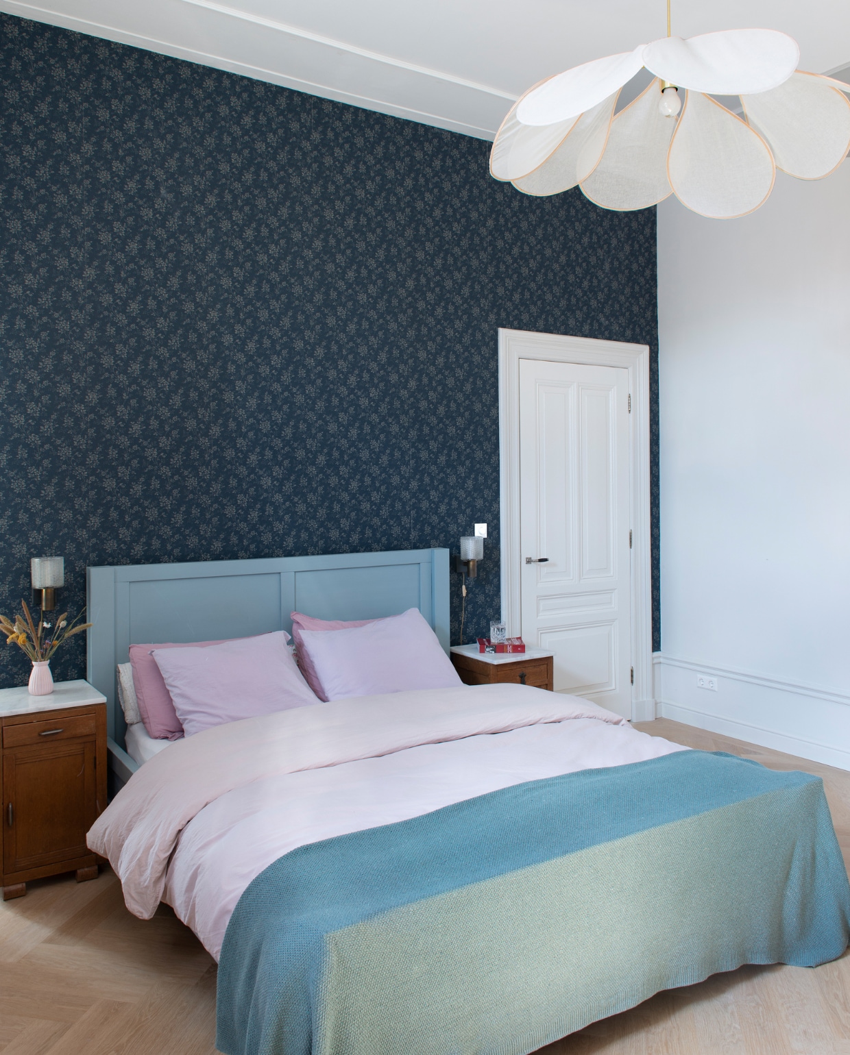 Behang Borastapeter. Verfkleur Slaked Lime Mid van Little Greene. Bed zelfgemaakt. Beddengoed Crisp en H&amp;M Home. Sprei By Mölle. Nachtkastjes, wandlampen en vaas Marktplaats. Hanglamp Georges Store. vtwonen special binnenkijken 03-2023 | productie De Binnenkijkers | styling Jeske Weel  fotografie Caroline Coehorst
