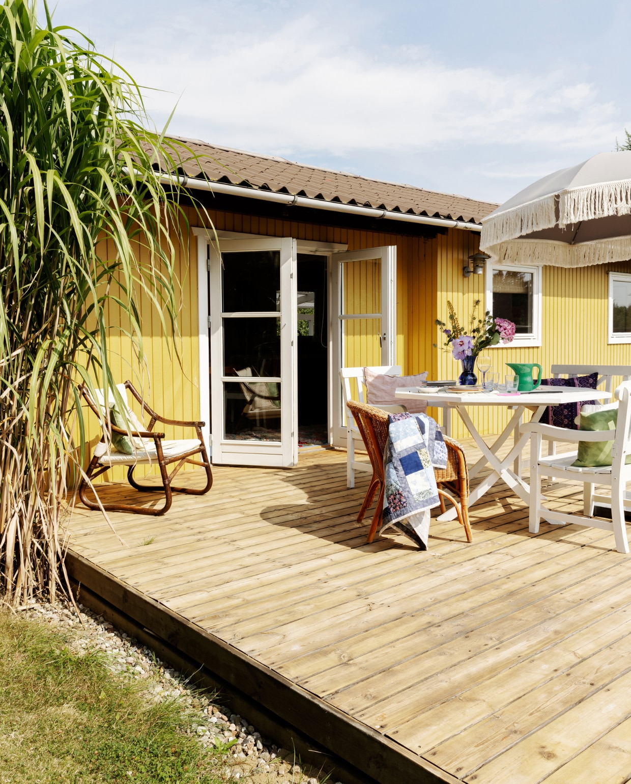 De witte tuinmeubels hoorden bij de inboedel van het huis. Parasol Ellos. Overig tweedehands op de kop getikt. vtwonen 07-2023 | productie Living Inside | styling Rikke Graff Juel | fotografie Christina Kayser O.