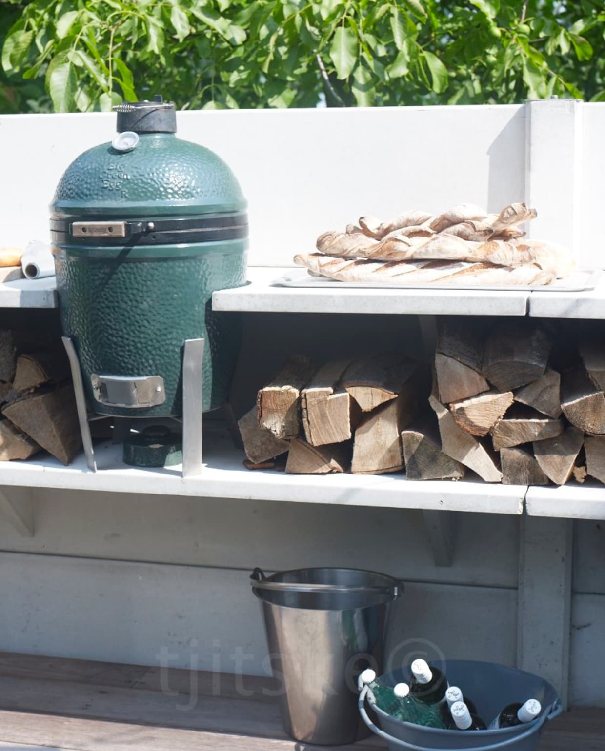 Barbecue met versterkte handgreep met hitteschild, porselein geëmailleerde deksel en ketel en ventilatierooster aan de zijkant: gezond barbecueën dankzij gecontroleerde luchttoevoer. Verchroomd bovenrooster, gesloten ketel, brikettenmaatbeker voor het exact afmeten van de juiste hoeveelheid briketten, stabiel onderrooster en stabiel frame met drie poten (Weber). vtwonen 05-2012 | styling Fietje Bruijn | fotografie Tjitske van Leeuwen