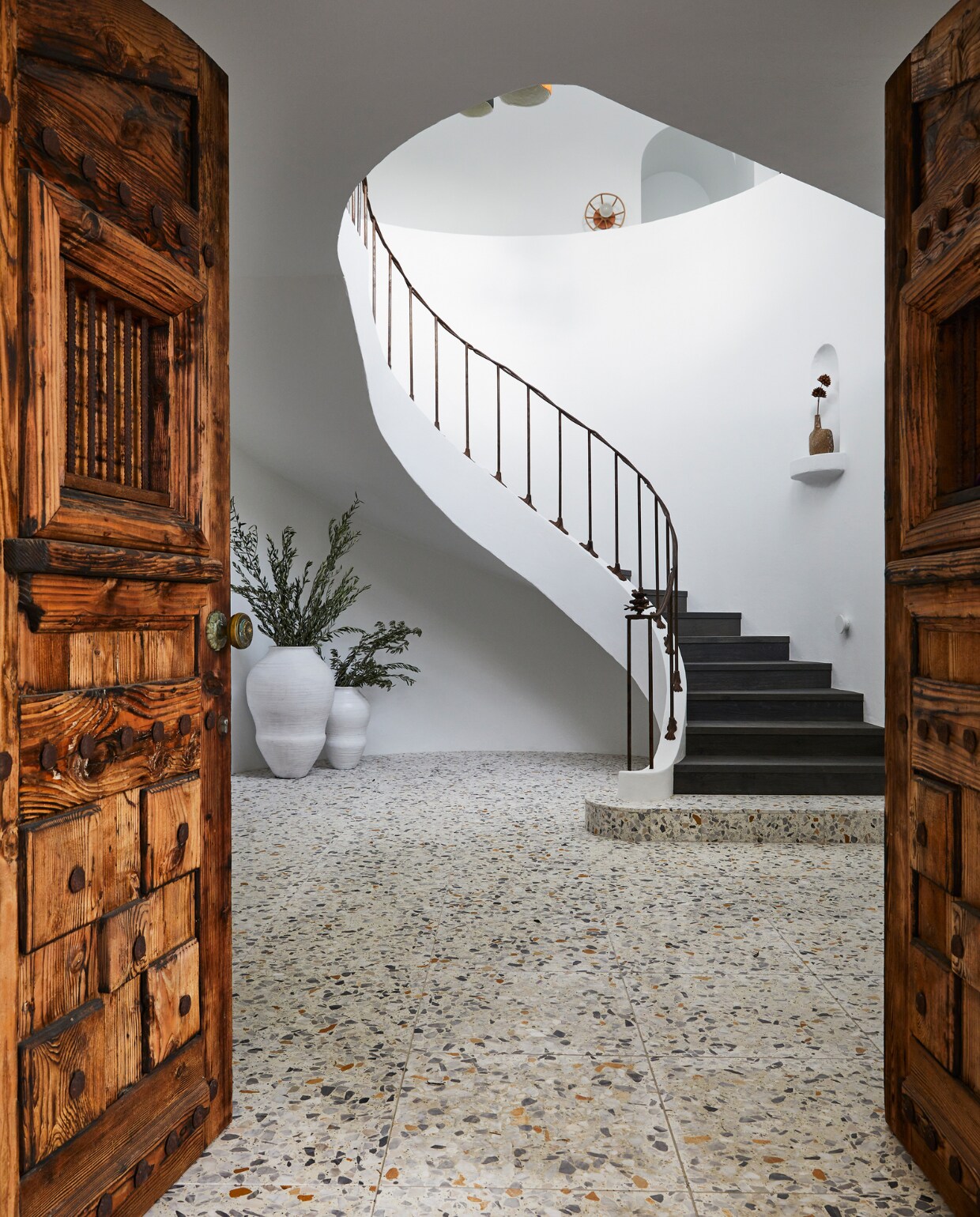 Originele voordeuren van massief hout. Terrazzo vloertegels Ciottolo Grande van Ceramica Senio. Bloempotten Insingizi Pots Uniqwa Collections. vtwonen special binnenkijken 06-2022 | productie Living Inside | styling Julia Green | fotografie Armelle Habib