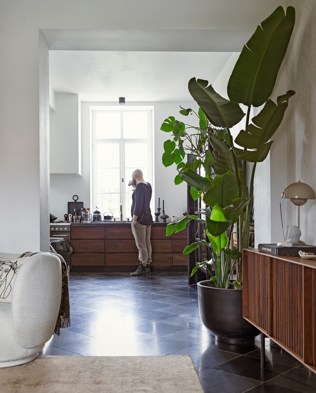 Vloerkleed Benuta. Dressoir Al2 via Decor Amsterdam. Lamp, plantenpot &amp;Tradition. Stoel Ferm Living. Kussen Leclaireur. Fornuis Boretti. Kraan Quooker. Planken Ca-Va! Kan met lepels Hay. Peper- en zoutmolen Oyoy Living Design. Grote pepermolen Maarten Baas. Broodrooster Kitchenaid. Theepot Serax. Kandelaars Anissa Kermiche. vtwonen 11-2021 | styling Ilona Jongepier | fotografie Dana van Leeuwen | visagie Djolien de Kreij