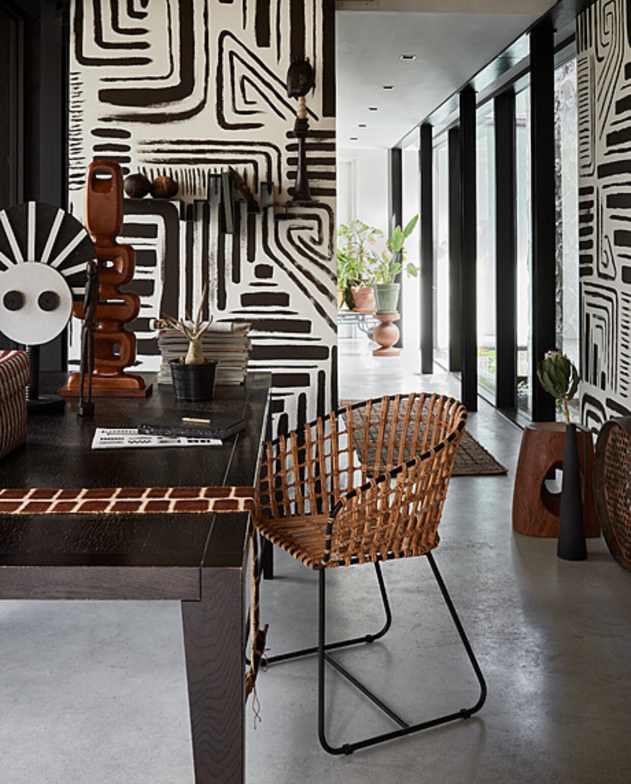 Muurverf wandschildering Charcoal van Lab Paint (vestingh.nl). Tweedehands tafel, 220x100x75 cm (lxbxh), tweedehands object op voet, 55 cm (h), tweedehands Afrikaans beeld, tweedehands kokosnoten op plank, tweedehands hoog beeld op plank, 50 cm (h) (dekringloper.nl). Teakhouten object, 25x9x71 cm (bxdxh) (hkliving). Opbergdoos Maxim, gerecyclede plastic strips (hay.nl). Wandhanger Totem Process van Aaaa, katoen geverfd met modder en kruiden (sukha.nl). Rotan stoel Tokyo, metaal, rotan en polyester, 53x54x79 cm (bxdxh), houten kruk Devil’s Eye, 30x25x45 cm (bxdxh), houten kruk Ball, 35x40 cm (Øxh), zwarte gepoedercoat metalen vaas Roman, 11,5x52 cm (Øxh), set van 4 (polspotten.com). Vintage zeef (vandijkenko.nl). Wandplank Storylines van Studio Frederik Roijé, 90x30x28 cm (lxdxh) (vtwonen.be/shop). Planten en potten, prijs op aanvraag (bydennis.nl). vtwonen 08-2023 | styling Fietje Bruijn | fotografie Alexander van Berge