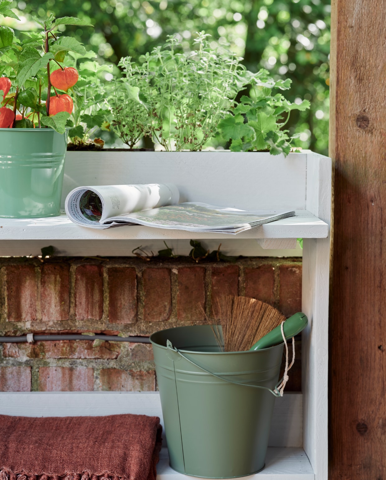 Zeegroene karaf, terra mokken Alva, klein, per stuk, linnen terra plaid (loods5.nl). Groene plantenpot (dille-kamille.nl). Groene emmer, plantenhanger, terra plantenpot Diego (intratuin.nl). Espadrilles en zonnebril privébezit. vtwonen 06-2023 tuin special 6 | styling Moniek Visser | fotografie Sven Benjamins