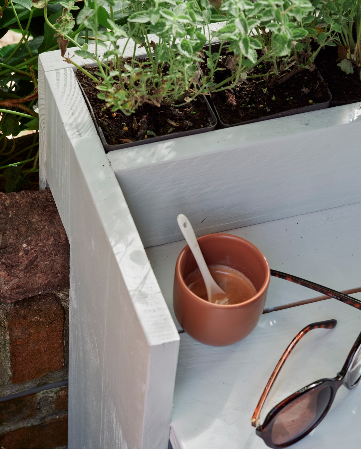 Zeegroene karaf, terra mokken Alva, klein, per stuk, linnen terra plaid (loods5). Groene plantenpot (dille-kamille). Groene emmer, plantenhanger, terra plantenpot Diego (intratuin). Espadrilles en zonnebril privébezit. vtwonen 06-2023 | Tuin special 6 | Styling Moniek Visser | Fotografie Sven Benjamins