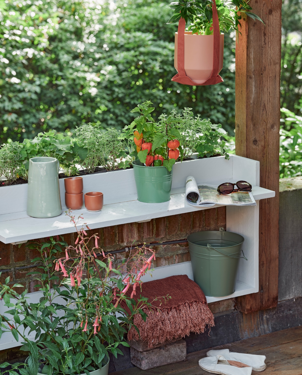 Zeegroene karaf, terra mokken Alva, klein, per stuk, linnen terra plaid (loods5.nl). Groene plantenpot (dille-kamille.nl). Groene emmer, plantenhanger, terra plantenpot Diego (intratuin.nl). Espadrilles en zonnebril privébezit. vtwonen 06-2023 tuin special 6 | styling Moniek Visser | fotografie Sven Benjamins