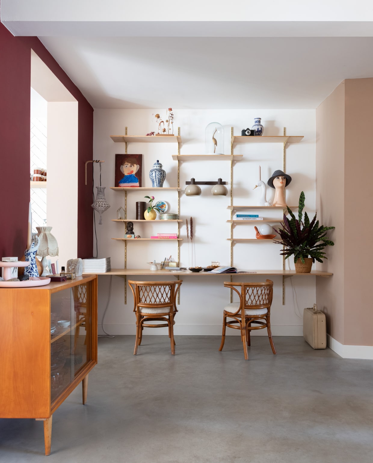Kast en bureau op maat gemaakt. Op de planken: zelfportret door zoon Len, Delfts blauwe vaas en mannequinhoofd tweedehands, vogel en stolp Sprinkelhop, kandelaar zwaan Zusss, hoed cadeau. Stoelen en wandlamp tweedehands. Hanglamp gehaakt door Annemaries zus. Koffer Vintage Friends. Overig onbekend. vtwonen special binnenkijken 03-2023 | styling Sharon Roest | fotografie Caroline Martinot