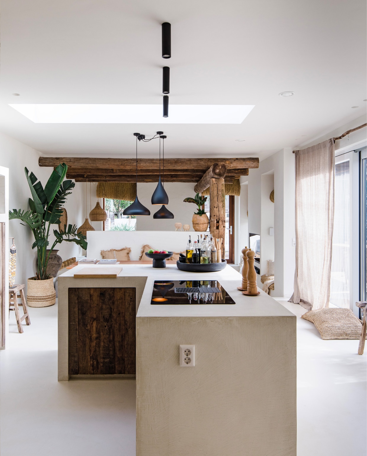 Vloer, muur en keuken gestuukt door Elite Deco. Keukenkastfronten Van Feij houthandel, zwarte lampen, opbouw- en inbouwspots Nova Luce. Eetkamerstoelen Goossens Wonen, eettafel in Indonesië laten maken, houten Chinese kruk Van Hees Design. Zeegras rolgordijnen in Marokko laten maken, linnen gordijnen Ikea, gordijnroede stok uit het bos. Overig Coco homeliving. vtwonen 08-2023 | fotografie Corine Hoge Bavel-Jansen