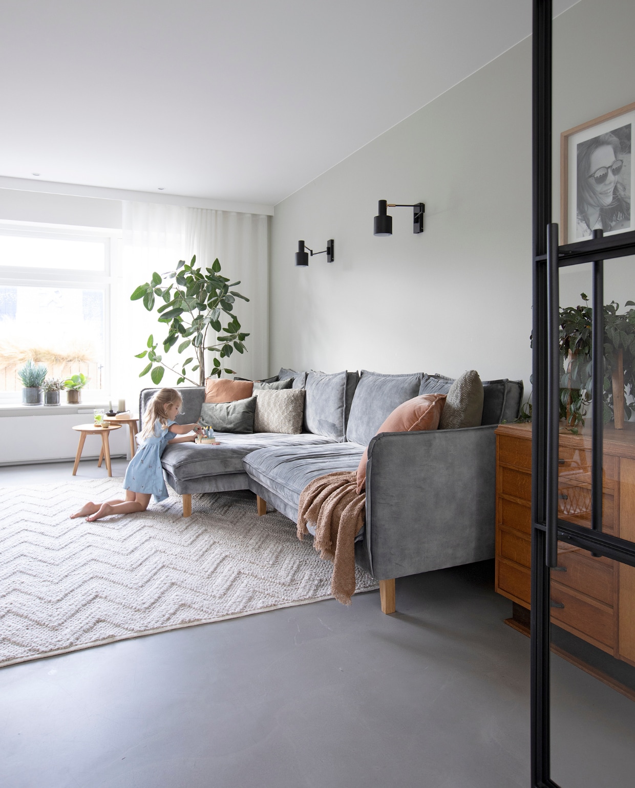 Bank Aardeko. Vintage kast Markplaats. Bijzettafels Mørteens. Wandlampen en vloerkleed Kwantum. Kussens Lifestyle, Goround Interior en Intratuin. Sprei H&amp;M Home. Fotolijsten HKliving. Planten en potten Zorgkwekerij Bloei. Gordijnen Van Schie Raamdecoratie &amp; Stoffen. vtwonen 08-2021 | Fotografie Macha Gutlich