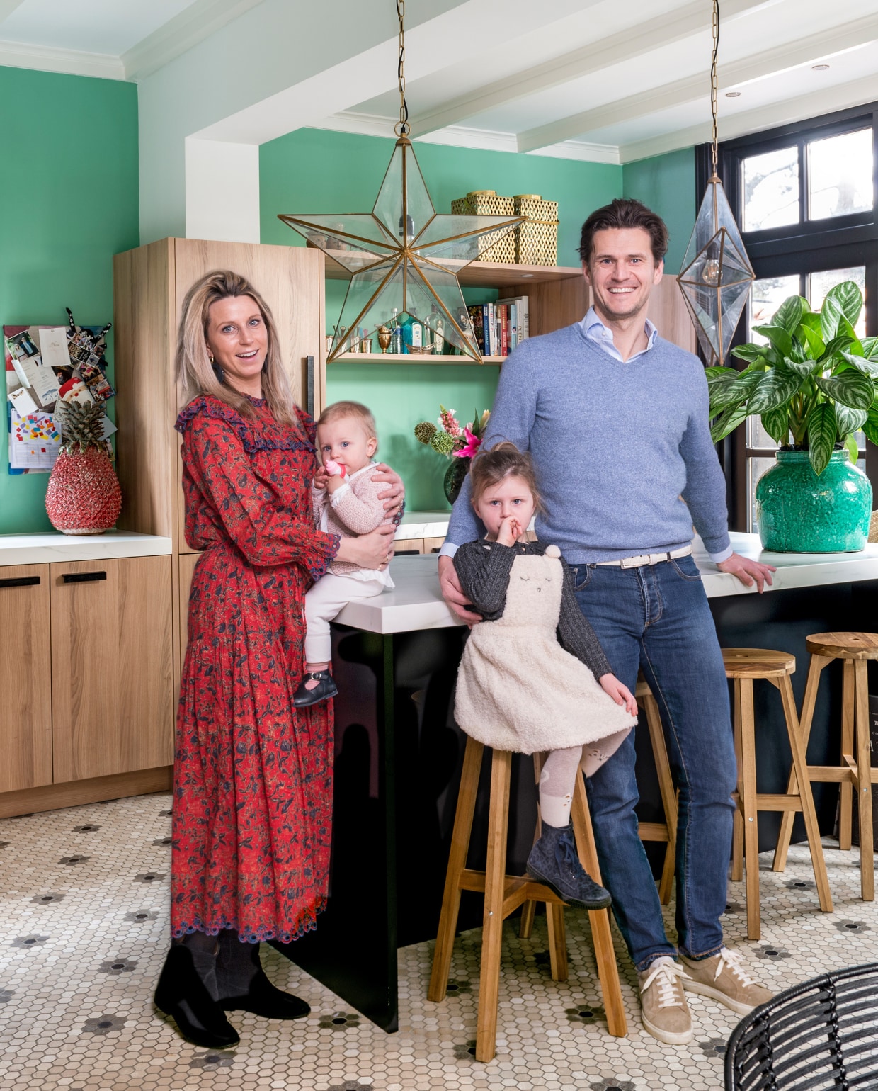 Sophie, Diederik, Guusje en Cato. Keuken van Piet Boon. Stervormige lamp van Sissy-Boy. Plantenpot Mica Decorations. Vloertegels van designtegels.nl. Krukjes Ikea. Ananas links op het aanrecht komt uit Parijs, evenals de windlichten boven op de keukenkast, verkrijgbaar bij Studio Sophie. Muurverf kleur Arsenic van Farrow &amp; Ball. vtwonen special binnenkijken 12-2019 | styling Lindividu | fotografie Stan Koolen, CocoFeatures