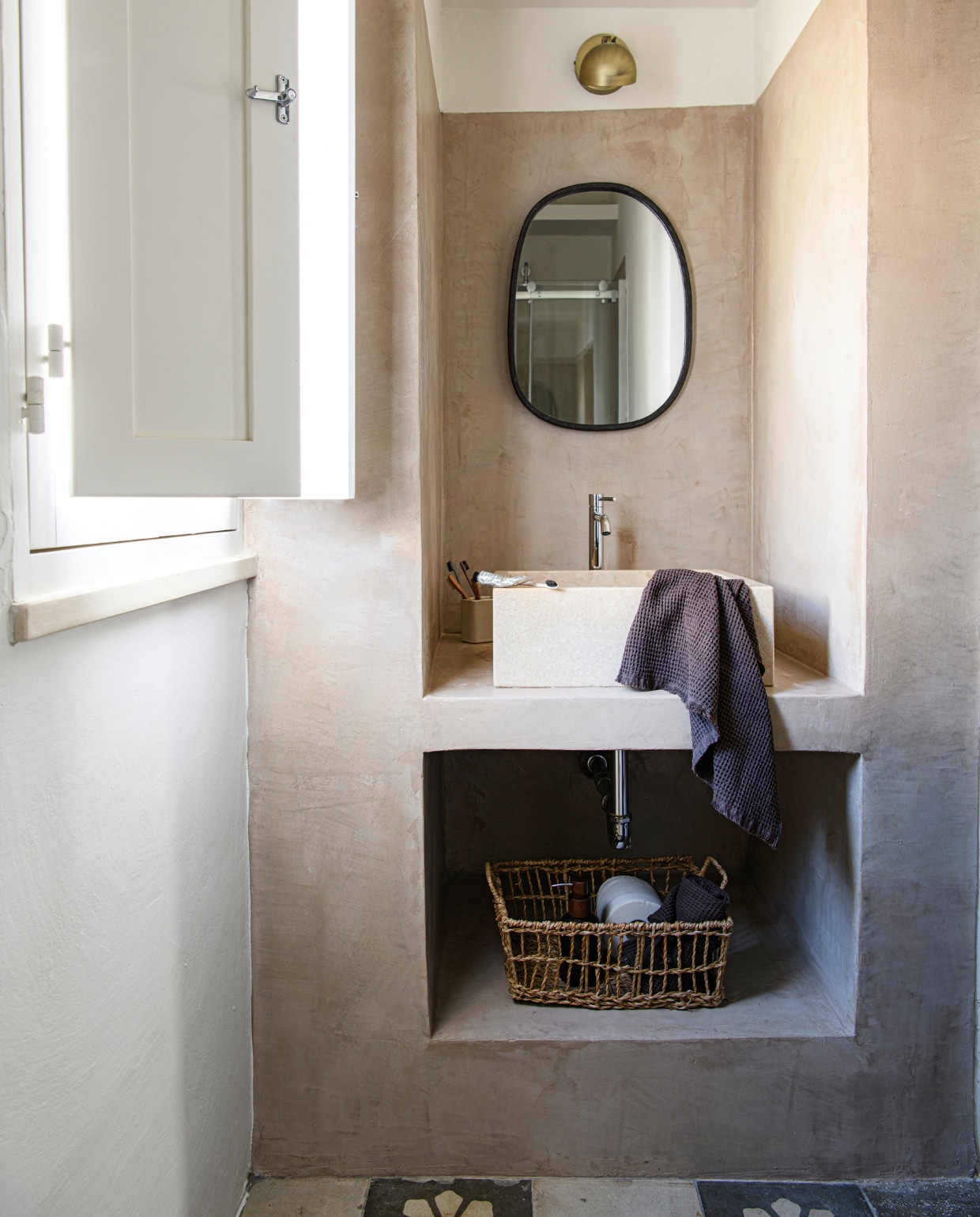 Wastafel van travertijn. Lamp Globen Lighting. Spiegel Bloomingville. Verfkleur North Sea Silt van Pure &amp; Original. Overig onbekend. vtwonen special binnenkijken 06-2023 | productie Insidehomepage | fotografie Louis Lemaire | styling Marit Saladini