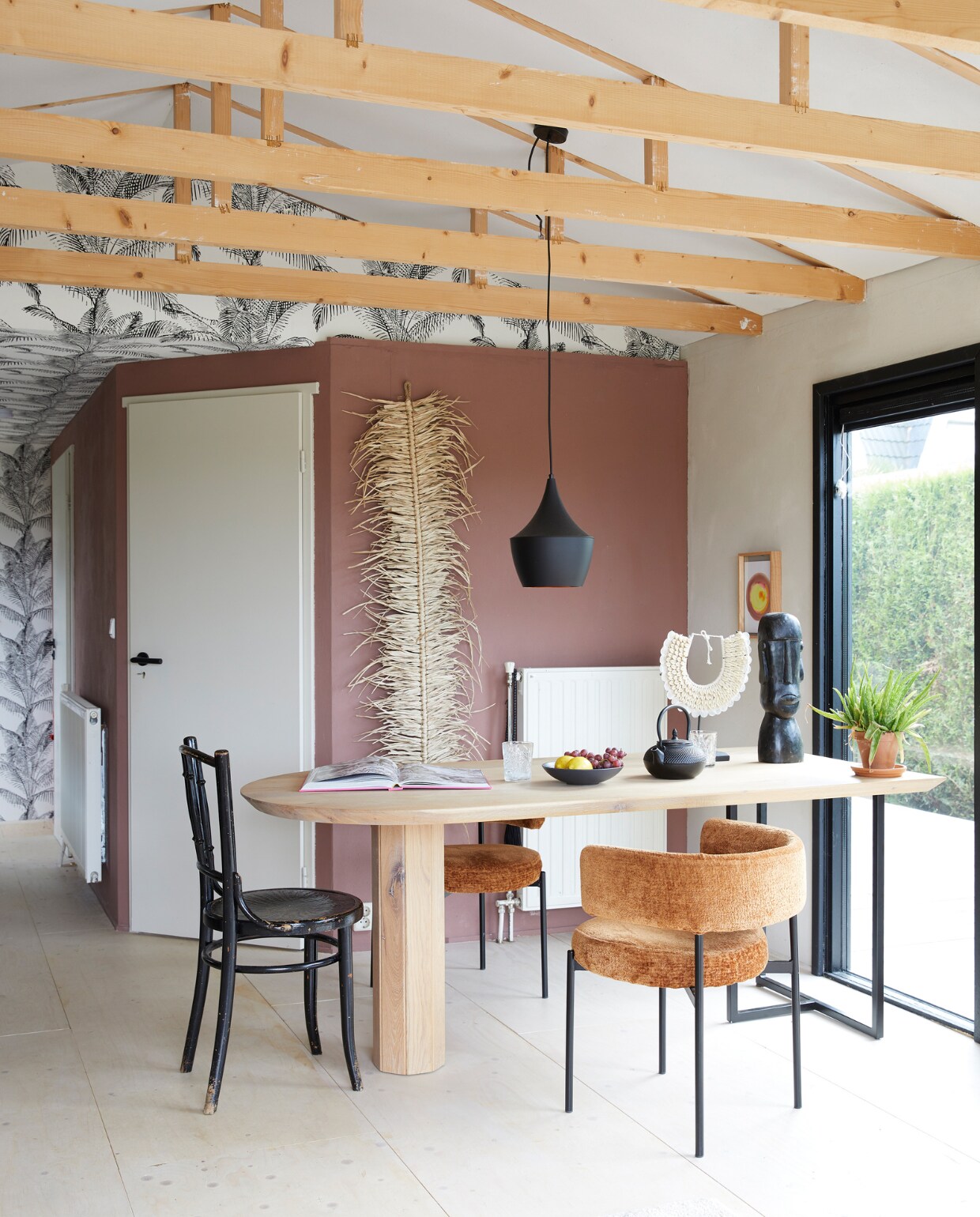 Stoelen Karwei, oude Thonet-stoel gevonden aan straat, op maat gemaakte tafel Meubelfabriek Crum. Buste en schelpenobject meegenomen uit Indonesië. Behang Pandore Palm van Rasch. Schilderij gemaakt door een vriendin, lamp online gevonden, muurverf zelfgemengd, overig onbekend. vtwonen 08-2023 | styling Linda van der Ham | fotografie Simone de Geus