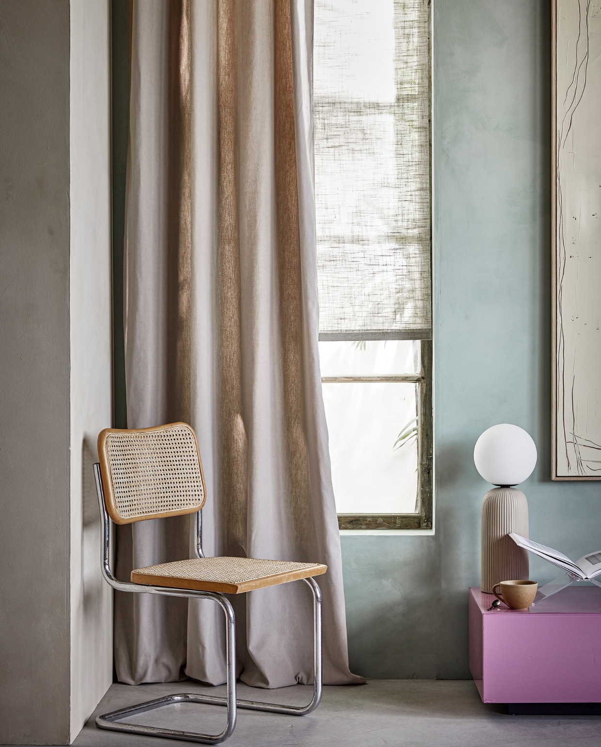 Lichtdoorlatend kant-en-klaar gordijn Denim Flax in taupe 1254, 140x270 cm (bxh), transparant kant-en-klaar rolgordijn Beach in zand 5916, 60x190 cm (bxh) (verkrijgbaar in meerdere breedtematen).M.m.v. zuiver.com (tafellamp), hkliving.com (salontafel, kunstwerk), pure-original.com (muurverf Poetic Blue), bauwerkcolour.com (lime paint Ibiza). Overig privébezit. vtwonen 08-2023 | styling Marlies Does | fotografie Peggy Janssen