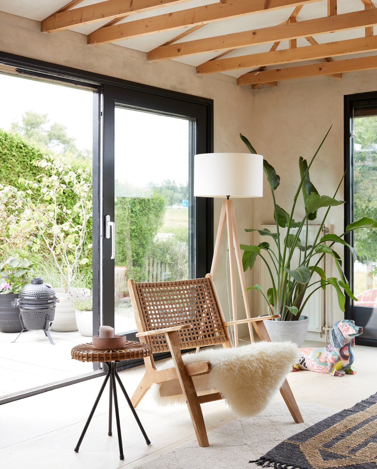 Fauteuil Grignoon van Kave Home, lampen in opdracht gemaakt, rieten bijzettafel erfstuk van een oom, kunstwerk teckel gemaakt door Lisa. Underlayment vloer gelakt. Overig onbekend. vtwonen 08-2023 | styling Linda van der Ham | fotografie Simone de Geus
