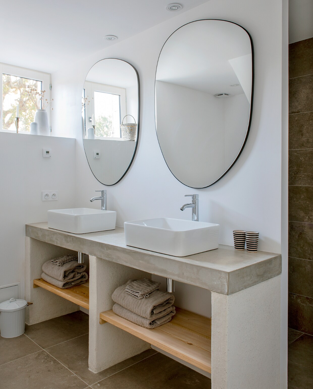Badmeubel zelf ontworpen en uitgerust met een betonnen blad. Spiegels Zara Home. Bekers Tine K Home. Handdoeken Ikea. Overig onbekend. vtwonen special binnenkijken 06-2023 | fotografie Ton Bouwer | productie Monique van der Pauw