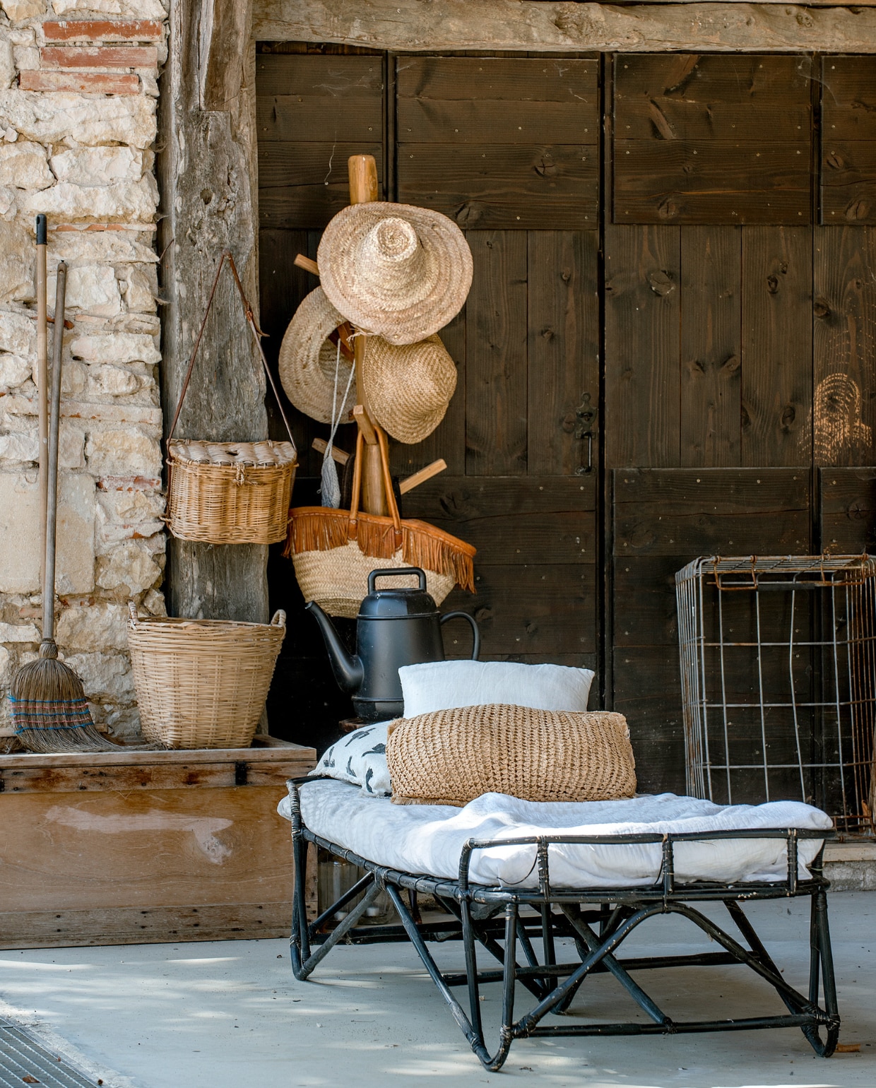 Daybed Madam Stoltz. Rieten manden, metalen mand, bezem en kist brocante. Overig onbekend. vtwonen special binnenkijken 06-2023 | fotografie Ton Bouwer | productie Monique van der Pauw