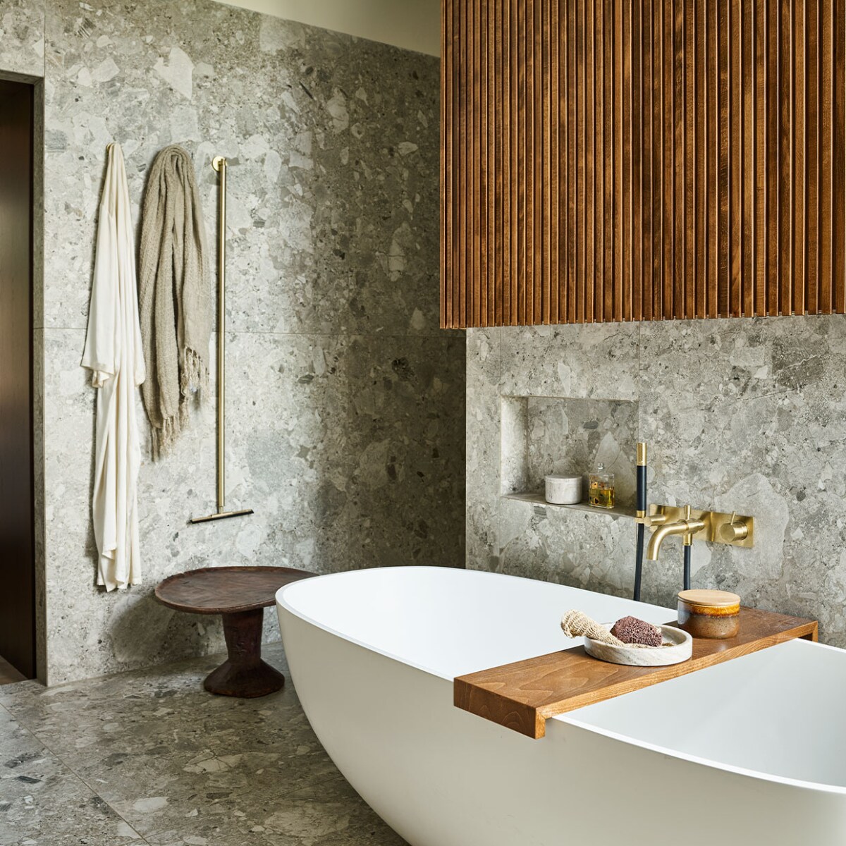 Vrijstaand bad Dado Quartz, prijs op aanvraag, grote tegels Light Grey Composiet uit de vtwonen-collectie, 120×120 cm, per m2 € 80,75, messing badmengkraan Hotbath Cobber CB026 met handdouche, vanaf € 798,60 (tonscholten.nl). Linnen badlaken € 80,50, marmeren schaal, € 69,95, marmeren potje, € 69,95 (nordal.eu). Houten bijzettafel Jimma, € 335,- (couleurlocale.eu). vtwonen 09-2021 | styling Cleo Scheulderman | fotografie Jeroen van der Spek