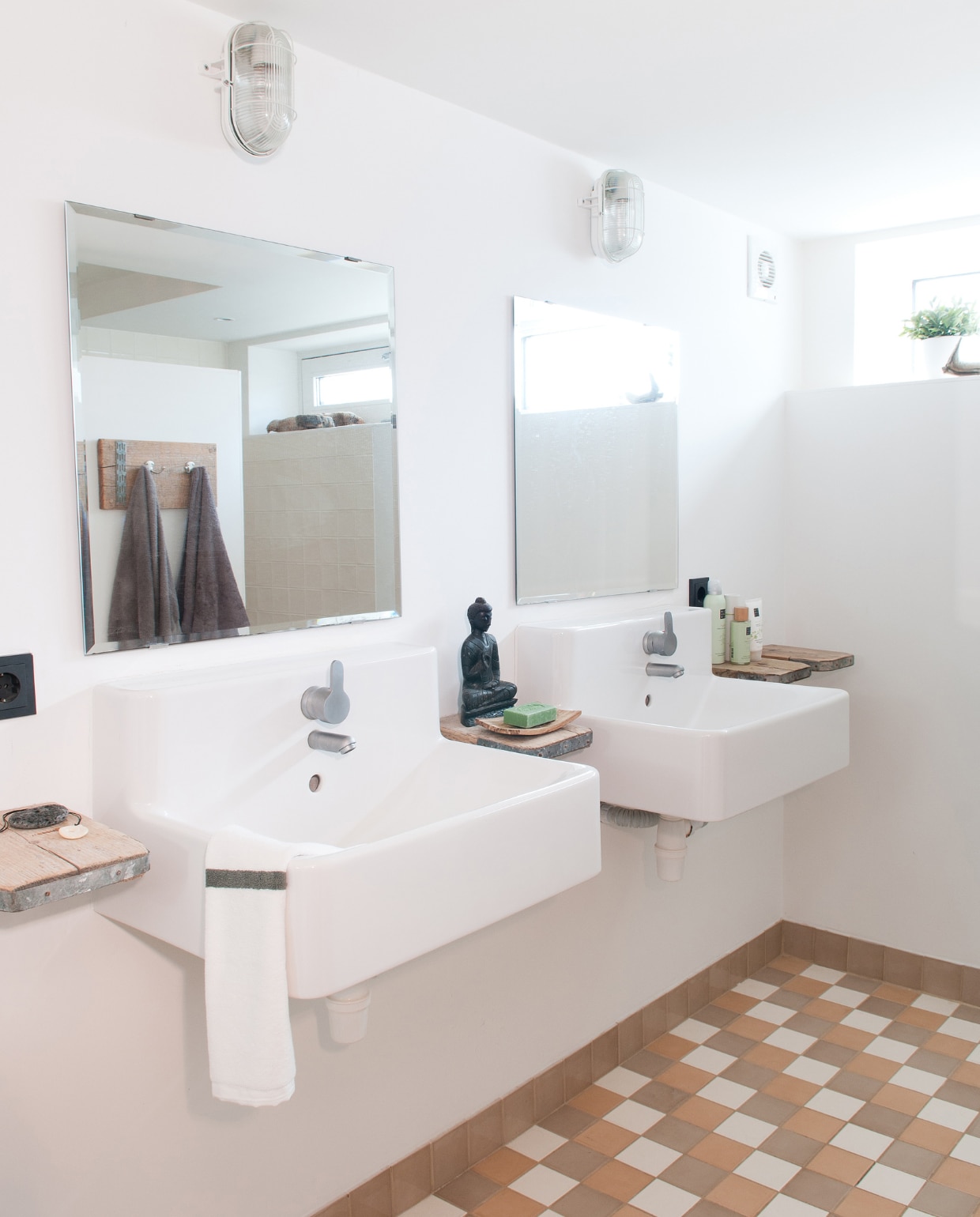 De badkamer bevindt zich deels onder het waterpeil; het raam steekt boven het water uit. De muren zijn hier gestuukt, de spiegels direct op de muur geplakt. Wastafels van Ikea. Het boeddhabeeldje kwam mee terug van een reis naar Sri Lanka, ervoor ligt een stuk lava uit IJsland. Het patroon van de tegels is bedacht door Natasha zelf. De tegels kochten ze bij een bedrijf dat nu niet meer bestaat. Metalen lampen Praxis. vtwonen 03-2017 | styling Irene van den Brink | fotografie Suzanne Paap
