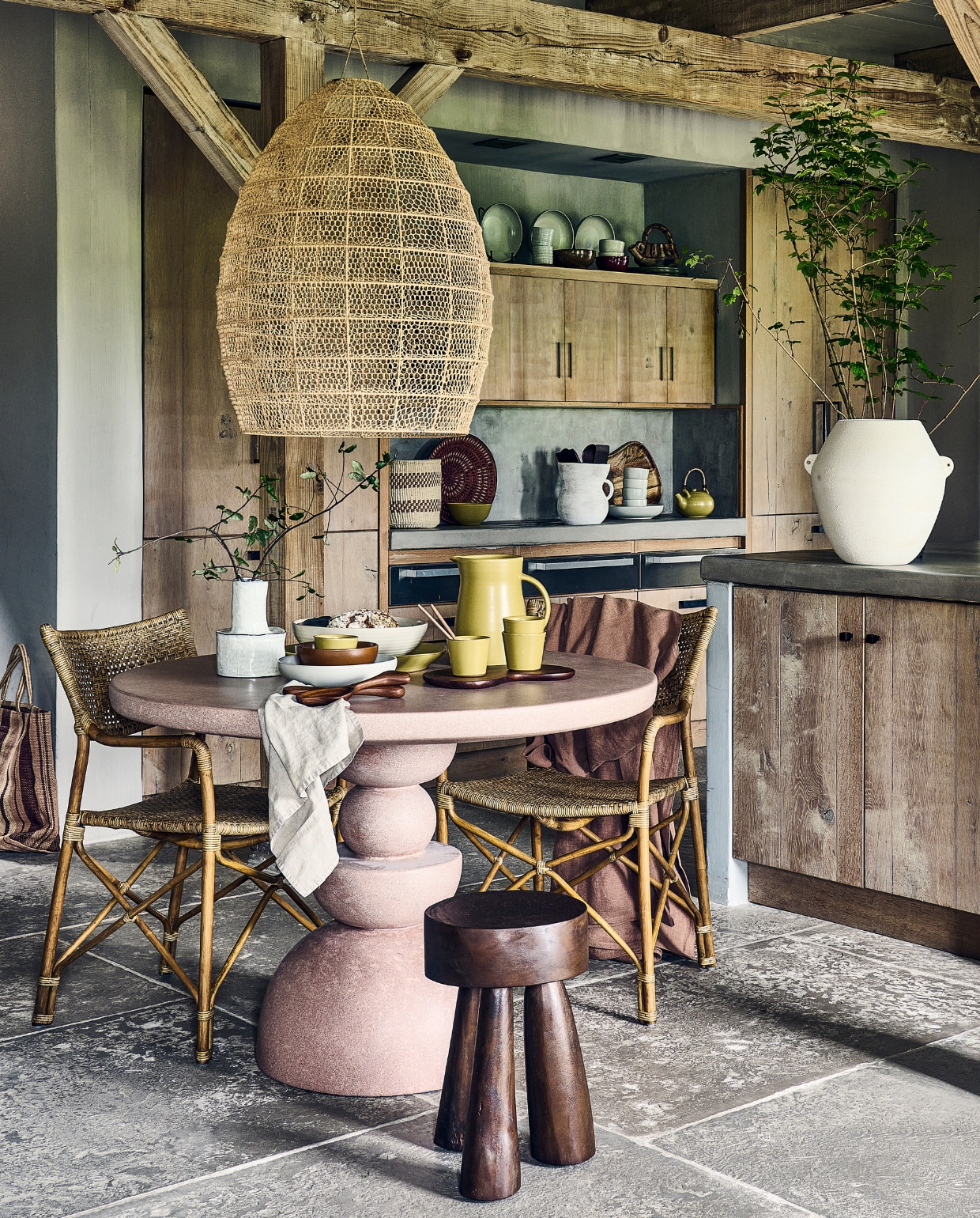 Roze cementen tafel Gijon € 1999,- (lanena-home.com). Macramé hanglamp, raffia met metalen structuur, 50x70 cm (Øxh) € 395,-, rotan stoel Sabany, 55x55x85 cm (bxdxh) € 475,-, jute tas Mati Jumbo € 85,-, sisal mand uit Kenia € 47,-, mand Kavango uit Namibië € 79,- (couleurlocale.eu). Houten bijzettafel Marco, 32x42 cm (Øxh) € 249,-, witte keramieken vaas op aanrecht Relaxed € 59,95, witte aardewerken vaas op kookeiland Sava € 169,- (urbannatureculture.com). Witte aardewerken vaas op tafel Héléna van Serax € 39,-, essenhouten saladebestek Os van Ferm Living € 55,-, porseleinen kommen Midi van Ferm Living, set van 3 € 79,- (vtwonen.be/shop). Linnen tafelkleed van Himla, 250x145 cm € 129,- (debijenkorf.nl). Off-white geglazuurde stenen koppen Serena € 29,- (fermliving.com). Olijfgroene keramieken theepot € 59,-, olijfgroene keramieken kan € 139,-, olijfgroene theekoppen € 17,-, olijfgroene keramieken soepkom € 26,-, keramieken pastaborden Pebble € 34,- keramische theekop Pebble € 17,- (sukha.nl). Kan op kast (kringloopcentrumbollenstreek.nl). Snijplank € 29,99, beige servetset, set van 2 € 12,99 (hm.com). Overig privébezit. vtwonen 2023-09 | styling Liza Wassenaar | assistentie Lila Steijger, Judith Koers, Kula Isabelle Den Broek | fotografie Sjoerd Eickmans
