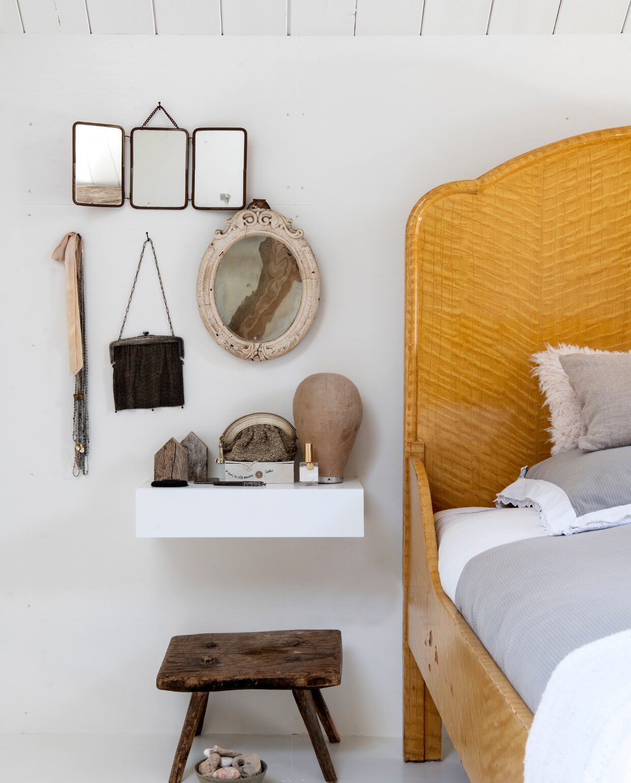Voorwerpen met een verhaal vormen een stilleven naast het bed in de ouderslaapkamer. Krukje via westwing.nl, handtasje van Anthropologie, beddengoed Sissy-Boy. Overig gevonden op vlooienmarkten en in kringloopwinkels. vtwonen 11-2019 | styling Esther Loonstijn | fotografie Louis Lemaire