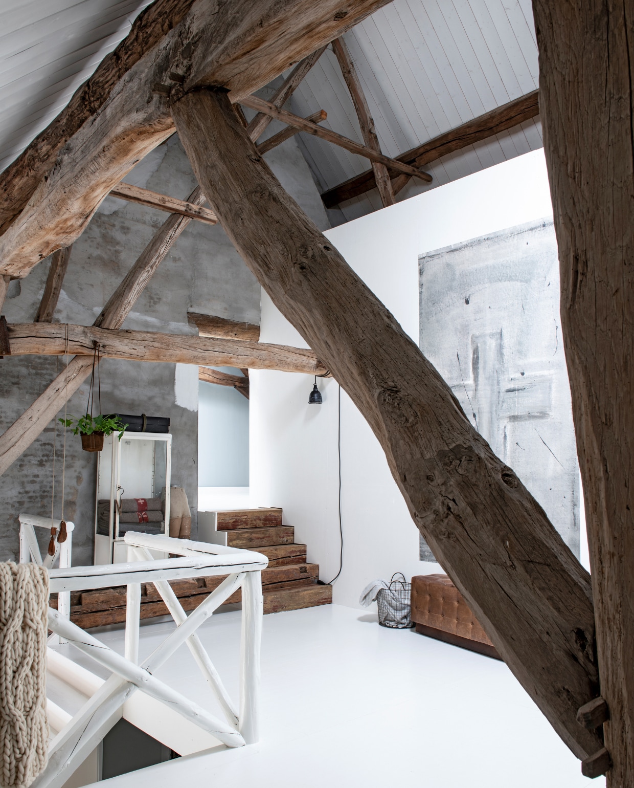 Op de voormalige hooizolder bevindt zich de overloop naar de slaapkamers. De balustrade is gemaakt van oude sporen uit de boerderij. Een balk die in de weg lag, is nu een trapje naar de kinderslaapkamers. Vintage apothekerskast en behang Cross Warm Grey Stapelgoed. vtwonen 11-2019 | styling Esther Loonstijn | fotografie Louis Lemaire