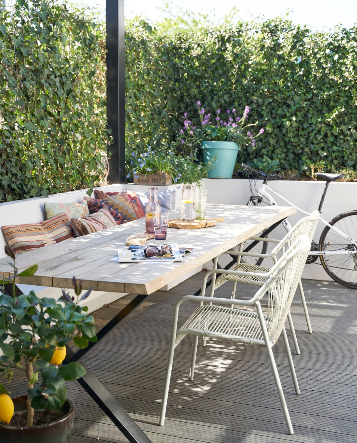Tafel Gewoon Wonen, stoelen Karwei, kelimkussens Bohemian du Maroc. Glaswerk Ikea. Ingebouwde bank, metalen pergola met ingebouwde verlichting (ook te gebruiken om een schaduwdoek aan te bevestigen) en plantenbakken eigen ontwerp en op maat gemaakt. vtwonen 08-2020 | productie Features &amp; more | styling Wilma Custers | fotografie Luuk Geertsen