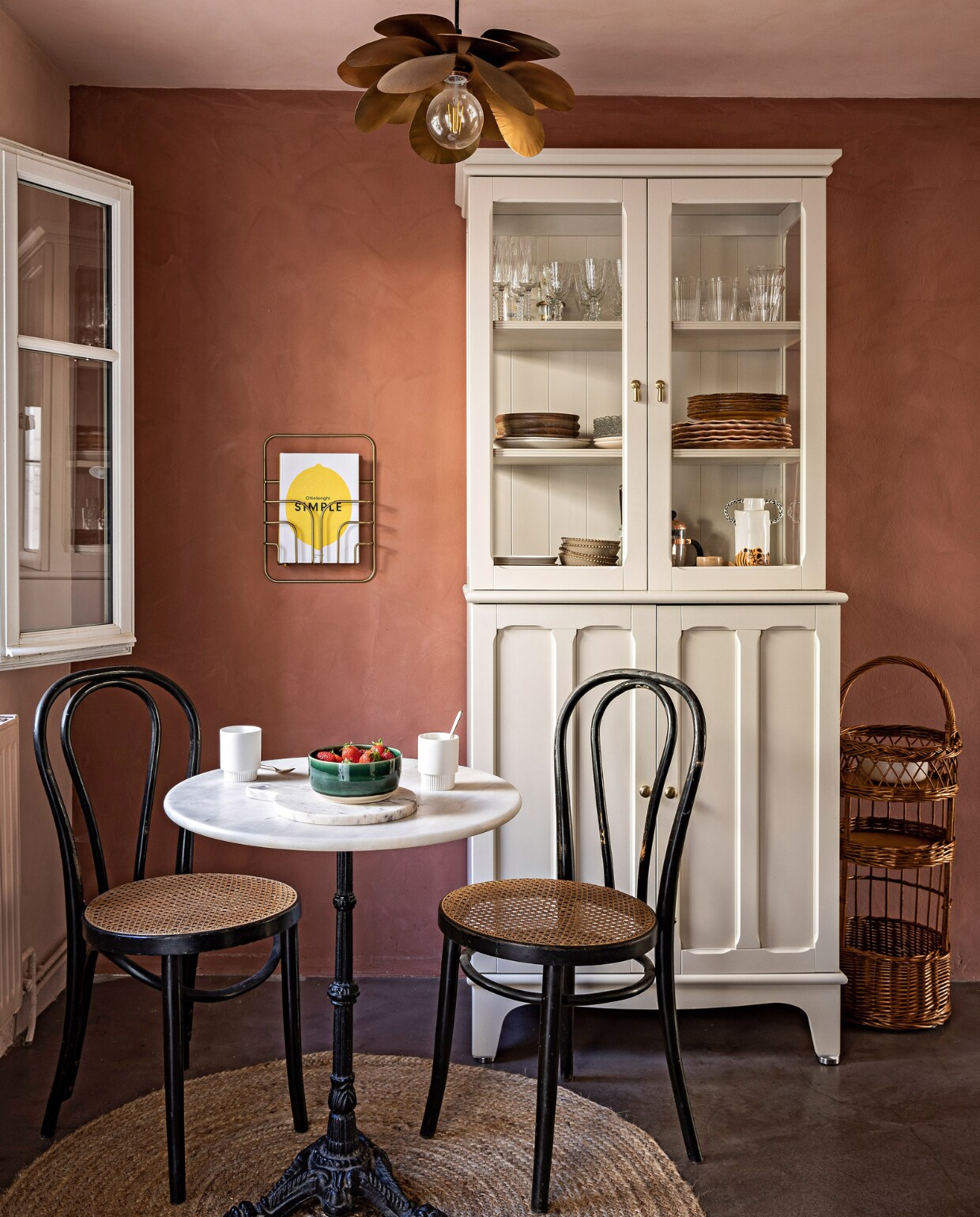 Gepolijste betonnen vloer Marius Aurenti. Muren geschilderd met leemverf Terre Rose van Ressource. Kast en zeegras vloerkleed Ikea. Bistrotafel vlooienmarkt. Vintage Thonet-stoelen Etsy. Hanglamp Cosmos van Caravane. vtwonen special binnenkijken 06-2023 | productie &amp; styling Marie Maud Levron | fotografie Yann Deret