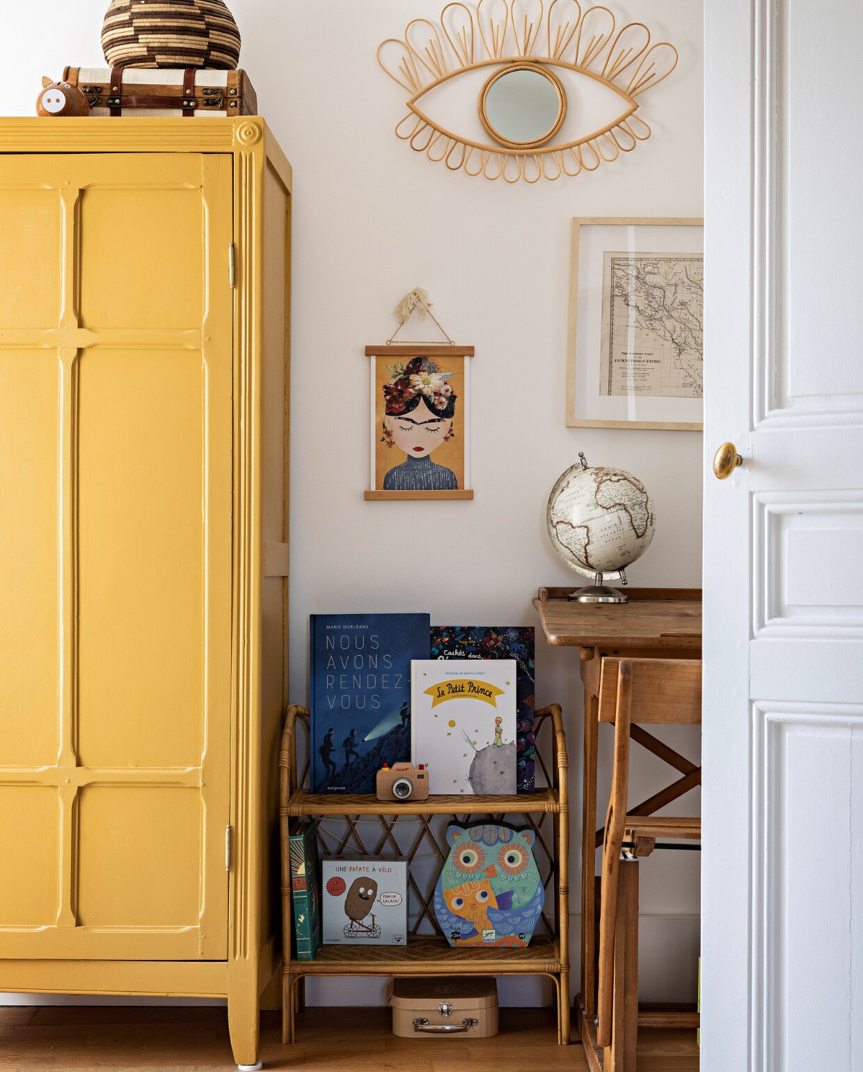 Tweedehands kledingkast, geschilderd in India Yellow van Farrow &amp; Ball. Vloerkleed La Redoute. Mand uit Botswana. Kast Bonton. Bureau, stoel en oude landkaart tweedehands. Poster Frida Juniqe. Overig onbekend. vtwonen special binnenkijken 06-2023 | productie &amp; styling Marie Maud Levron | fotografie Yann Deret
