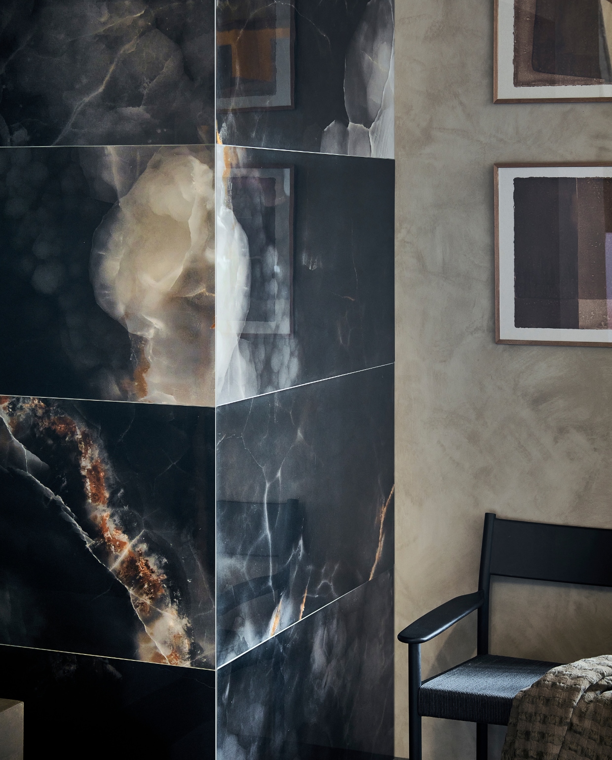 Tegels Onyx Deep Dark, 60x120 cm, per m² € 92,50.M.m.v. basiclabel.nl (fauteuil Lael van Woood), mooswillemsen.com (kunstwerken). vtwonen 09-2023 | productie Tanja Saarberg | styling Sanne Ketelaar | fotografie Sjoerd Eickmans