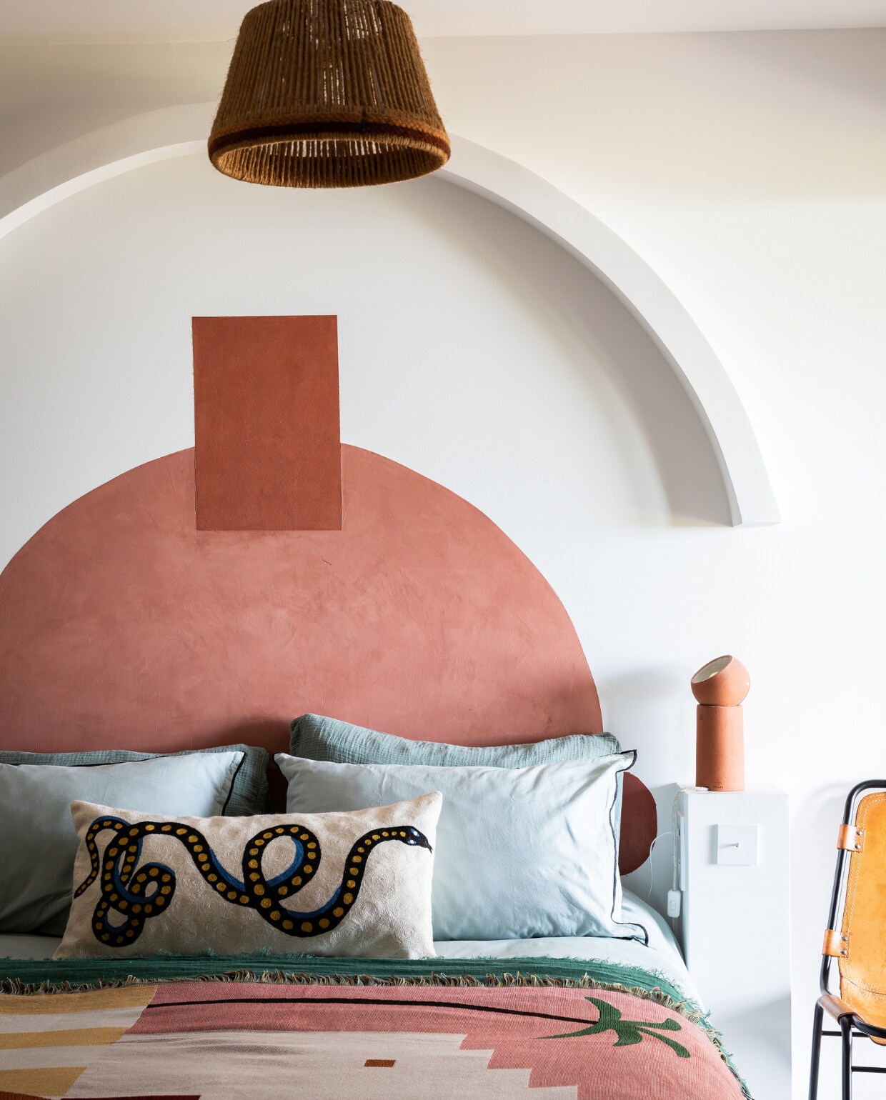 Bedsprei uit Mexico. Kussen slang Avdw Antwerp. Stoel Charlotte Perriand. Bedlamp Serax. Rotan hanglamp vintage. Beddengoed en verf onbekend. vtwonen 07-2023 | productie &amp; styling Marie Maud Levron | fotografie Yann Deret