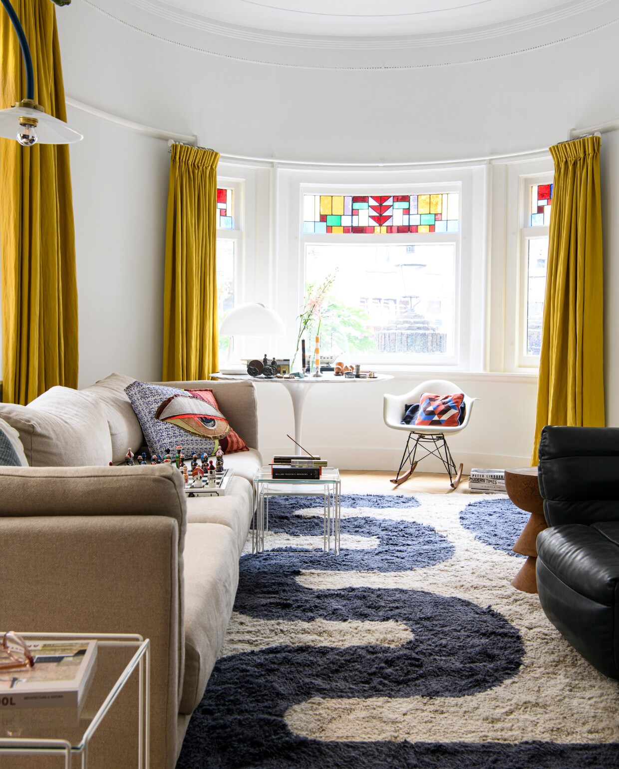 Schommelstoel Eames van Vitra, tafel Tulip van Saarinen, vloerkleed Zakaria Rugs, gordijnen gemaakt met stof van de markt. Overig onbekend. vtwonen | productie Insidehomepage | styling Kim Timmerman | fotografie Louis Lemaire