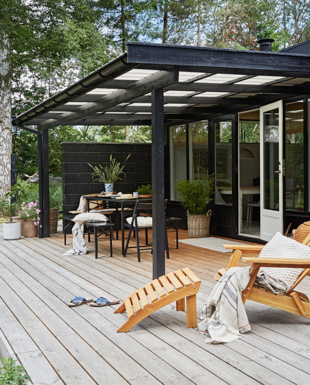 Ligstoel Coop. Dekens en kussens Zara Home en H&amp;M home. Eettafel en bankjes Dancover. Zwarte klapstoel Ikea. Houten bankje antiekmarkt. Vaas en kommen rommelmarkt. Overig onbekend. vtwonen special binnenkijken 06-2023 | productie Living Inside | fotografie Anitta Behrendt | styling Rikke Graff Juel