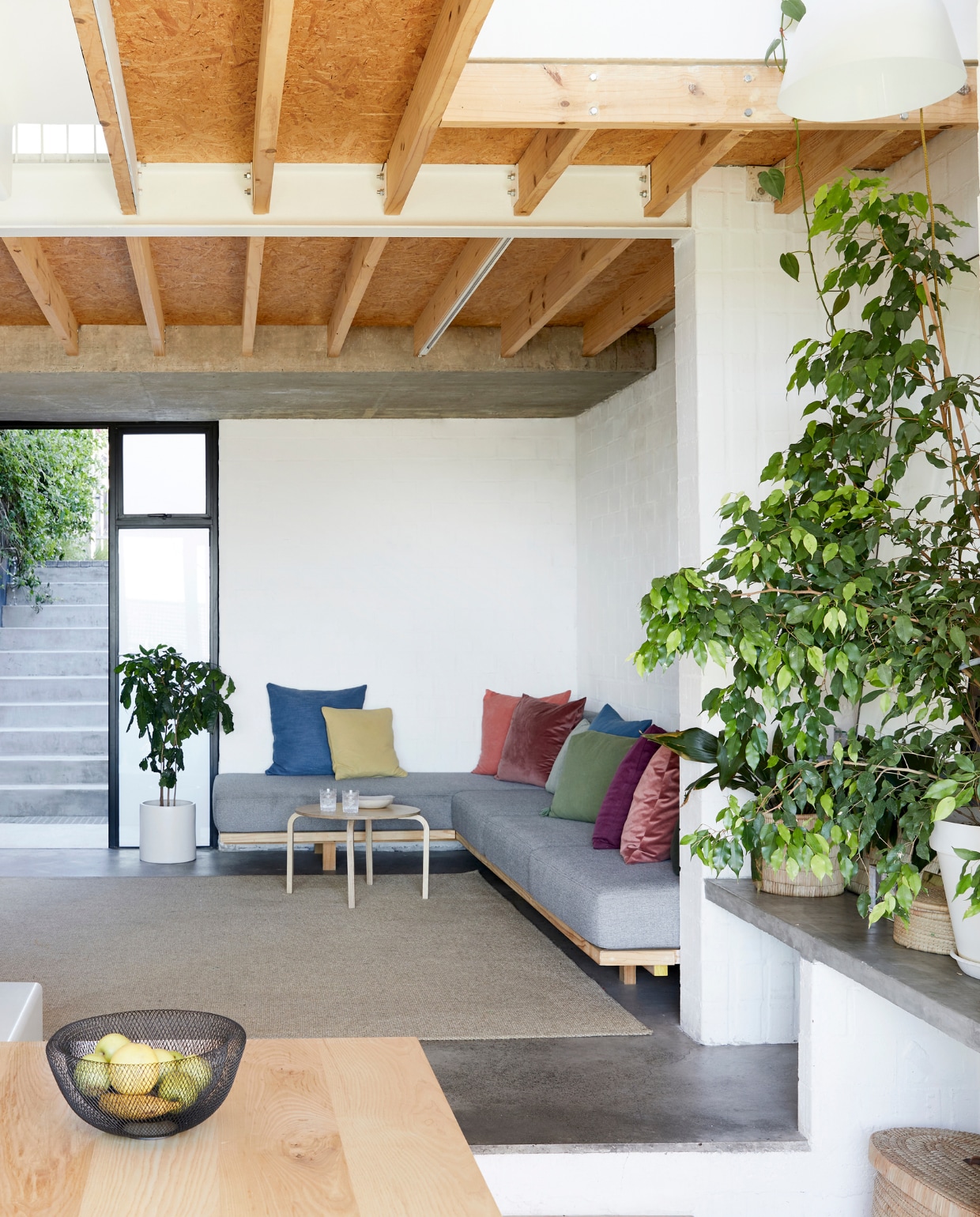 Bank en salontafel zelfontworpen en gemaakt door David Long. Plantenpotten tuincentrum. Vergelijkbare fruitschaal Fest Amsterdam. vtwonen special binnenkijken 03-2022 | productie Bureaux | fotografie Warren Heath | styling Sven Alberding