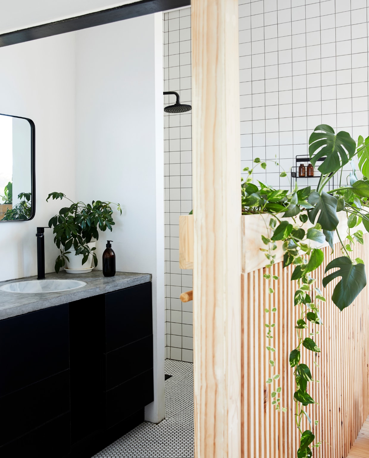In de ouderslaapkamer schermt een houten wand de inloopbadkamer af. Badmeubel Womag. Douche en kranen Gio Plumbing. vtwonen special binnenkijken 03-2022 | productie Bureaux | fotografie Warren Heath | styling Sven Alberding