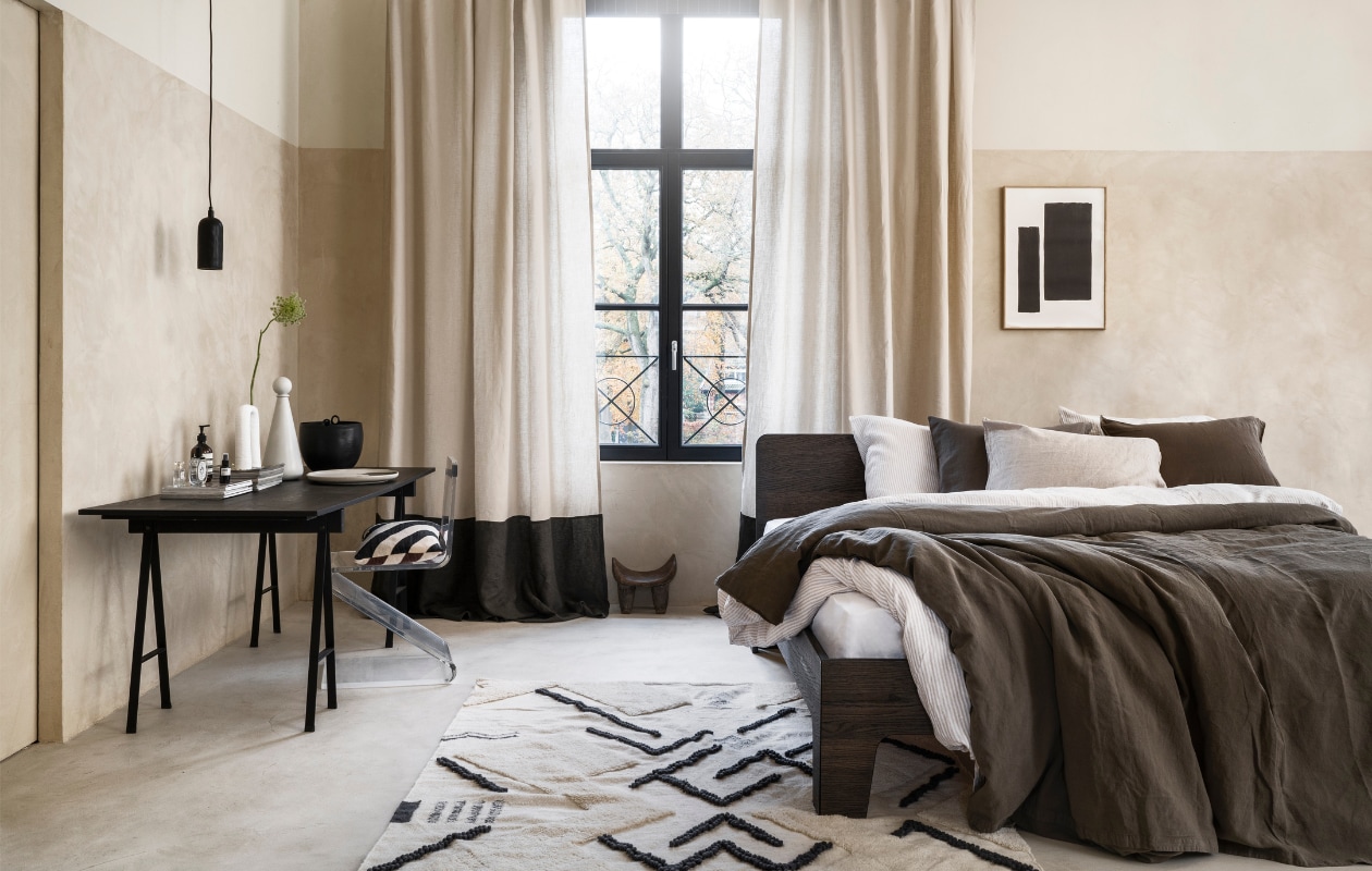 Stucco-look muurverf Mykonos, 2,5 liter € 110,- (wearewowmakers.com). Gordijn gemaakt van linnen Cloud Rider van Chivasso, per meter € 114,50 (jab.de). Bedombouw Pure, eiken fineer in Charcoal olie, 180x200 cm (bxd) € 3400,- (loof.nl). Duurzaam gewassen linnen dekbed-overtrekset met smalle strepen, 240x220 cm € 329,- (yumeko.nl). Bruine dekbedovertrekset, duurzaam linnen en katoen, 240x220 cm € 179,95 (suite702.com). Vloerkleed, 260x160 cm € 399,- (malagoon.com). Tafel van Serax, 150x75x73cm (lxbxh) € 824,-, vaas met bolvormig deksel van Ferm Living € 85,-, schaal Omhu van Ferm Living € 105,- (flinders.nl). Vintage transparante zigzagstoel € 350,- (neeflouis.nl). Hanglamp € 79,95, pot met oor € 62,95 (urbannatureculture.com). Vaas met twee poten van vtwonen € 49,95, gestreept kussen van Oyoy € 54,99 (vtwonen.nl). Poster met lijst vanaf € 95,- (loods5.nl). Afrikaans krukje privébezit. vtwonen 03-2023 | styling Marianne Luning | fotografie Stan Koolen
