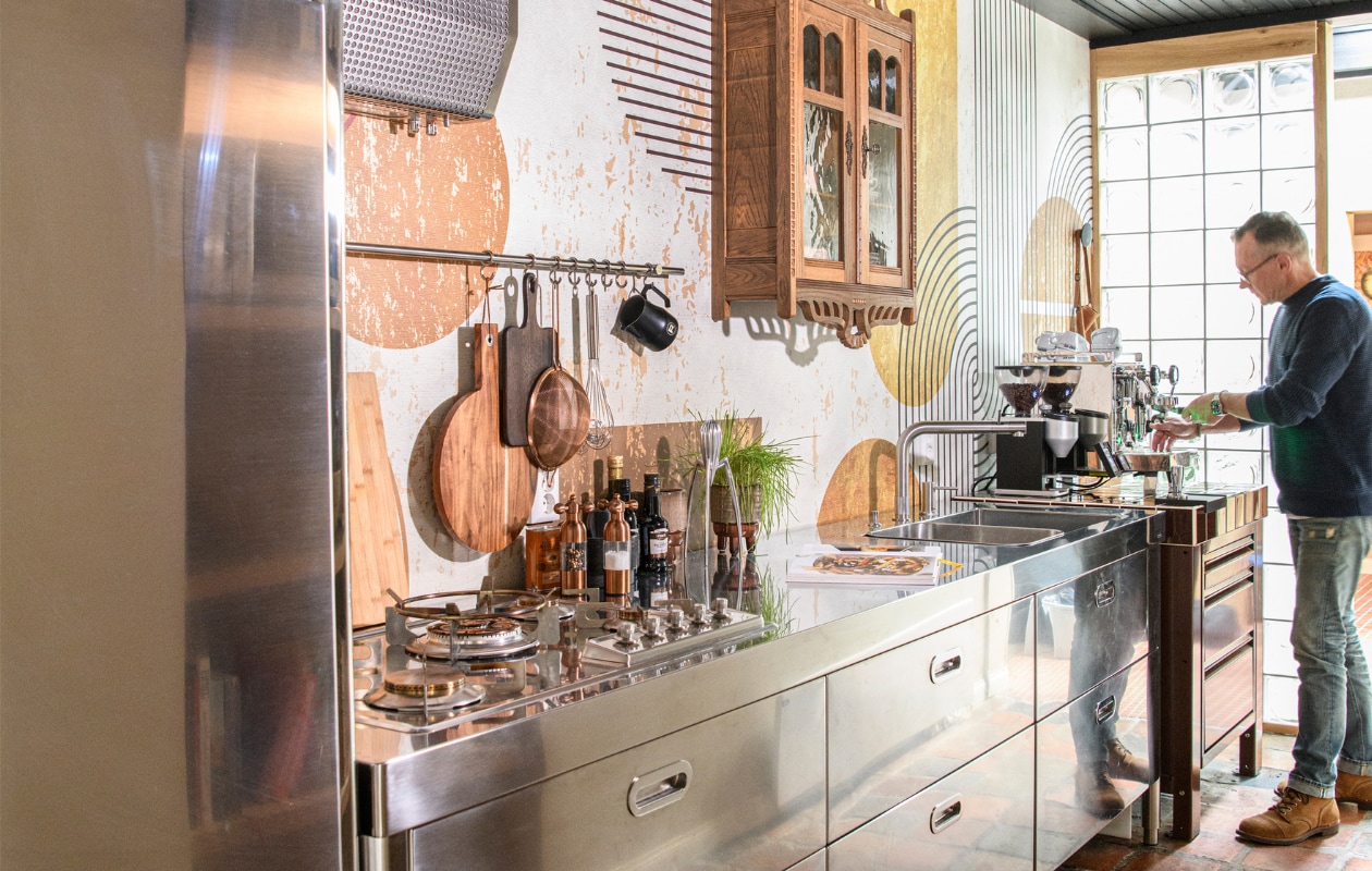 Eiken vitrinekast Marktplaats, servies Teema van Iittala, rvs keuken The Big Easy Kitchen. Naadloos behang Road Trip en structuurbehang Parangon van Casamance via Behangfabriek. Overig onbekend. vtwonen 10-2023 | styling Kim Timmerman | fotografie Louis Lemaire