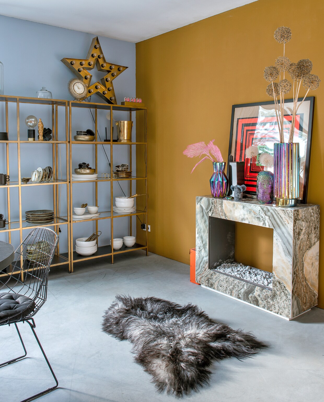 Kast Ikea, goud gespoten. Vacht Vachten van Terschelling, sterlamp Sissy-Boy, iriserende vazen de Bijenkorf. Schouw Karwei, zelf beplakt. Wit servies Dille &amp; Kamille, zwart servies rommelmarkt. Aardewerken servies en bollamp Tica. Gouden Maria-vaasje Loic Concept Store, print Sluiz, draadstoel vintage. Muurverf Bright Skies van Flexa en Old Ocre van Pure &amp; Original. Overig onbekend. vtwonen 10-2023 | fotografie Ton Bouwer
