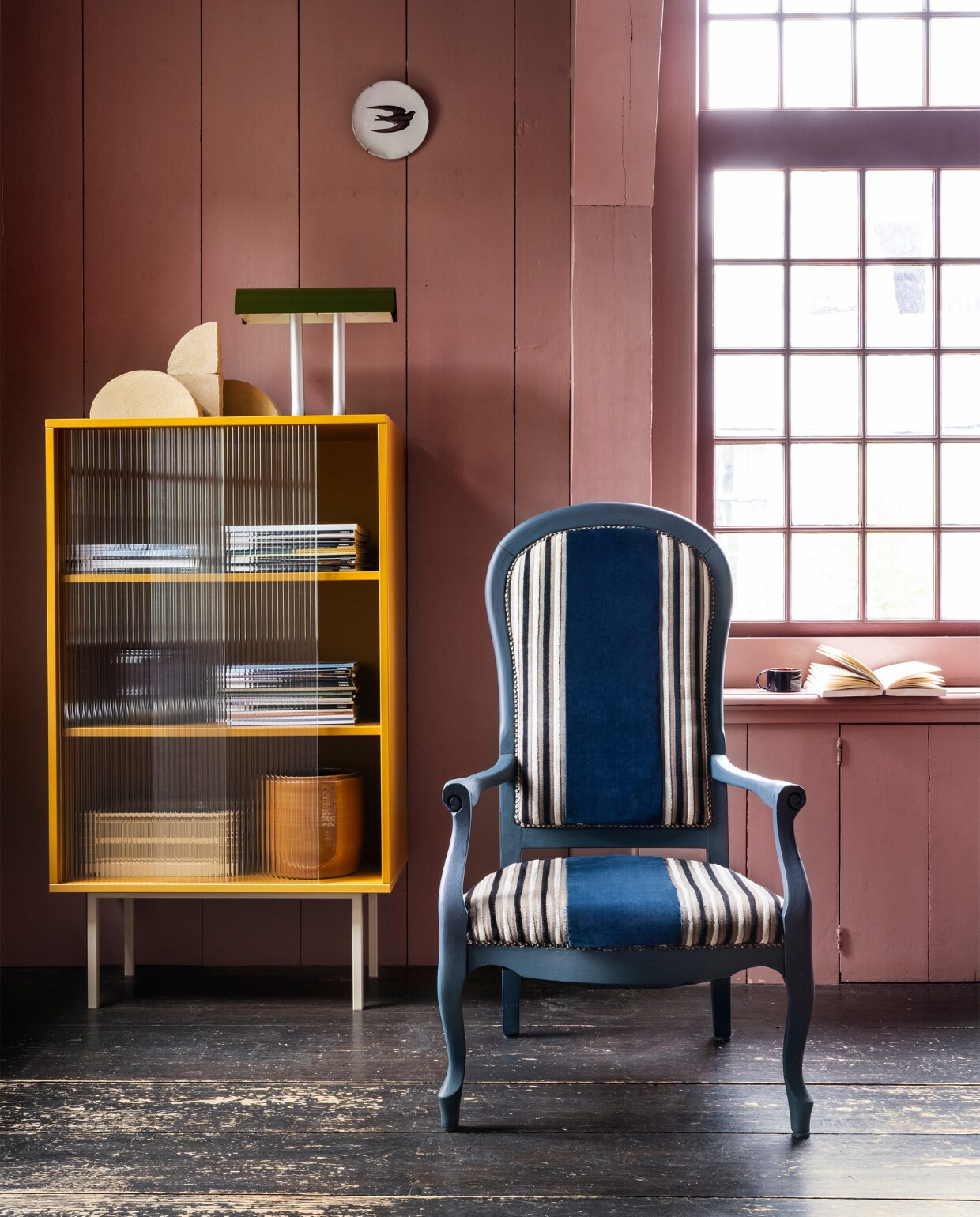 Tweedehands fauteuil € 29,95 (kringloopsaartje.nl). Blauwe verf Dead Flat in Hague Blue van Farrow &amp; Ball, per 0,75 liter € 52,- (deruamsterdam.nl). Velours stof Velluto di Cotone CA1410/053 van Carlucci, 140 cm breed, per meter € 140,- (jab.de). Vitrinekast Color Cabinet, staal en glas, 75x39x130 cm (bxdxh) € 1799,-, aluminium tafellamp Anagram € 295,- (hay.nl). Klei sculpturen Shape van Ferm Living, set van 4 € 175,-, aardewerken gele pot van Serax € 35,- (vtwonen.nl/shop). Bord Zwaluw van Astier de Villatte € 89,- (maisonnl.com). Overig privébezit. vtwonen 10-2023 | styling Marianne Luning | fotografie Stan Koolen | assistentie Rosa van Schie