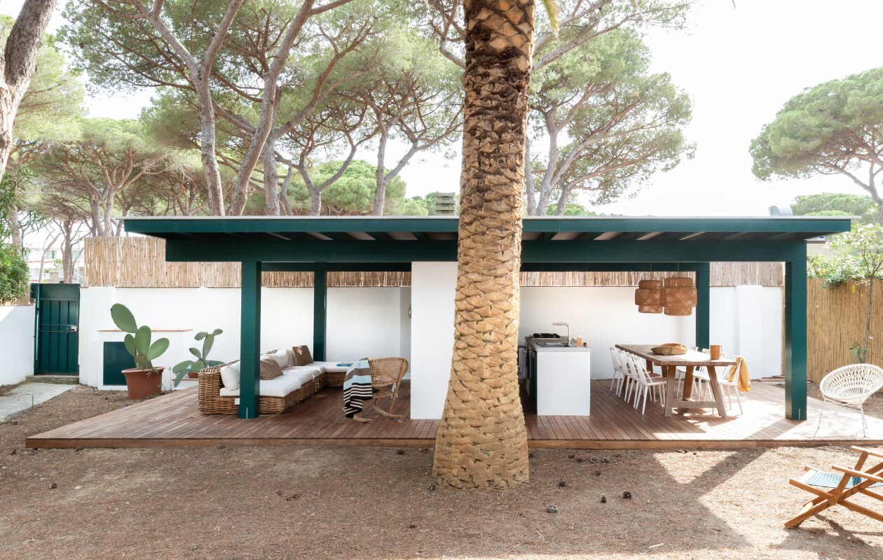 Loungebanken, tafel, stoelen, witte fauteuil en deckchairs Maisons du Monde. Schommelstoel Ikea. Hanglampen Sinnerlig van Ikea. Granieten keukenblad San Piero. Gootsteen en kraan Franke. Fornuis Smeg. Keramieken kan LRNCE. vtwonen special binnenkijken 06-2023| productie Living Inside | fotografie Monica Spezia