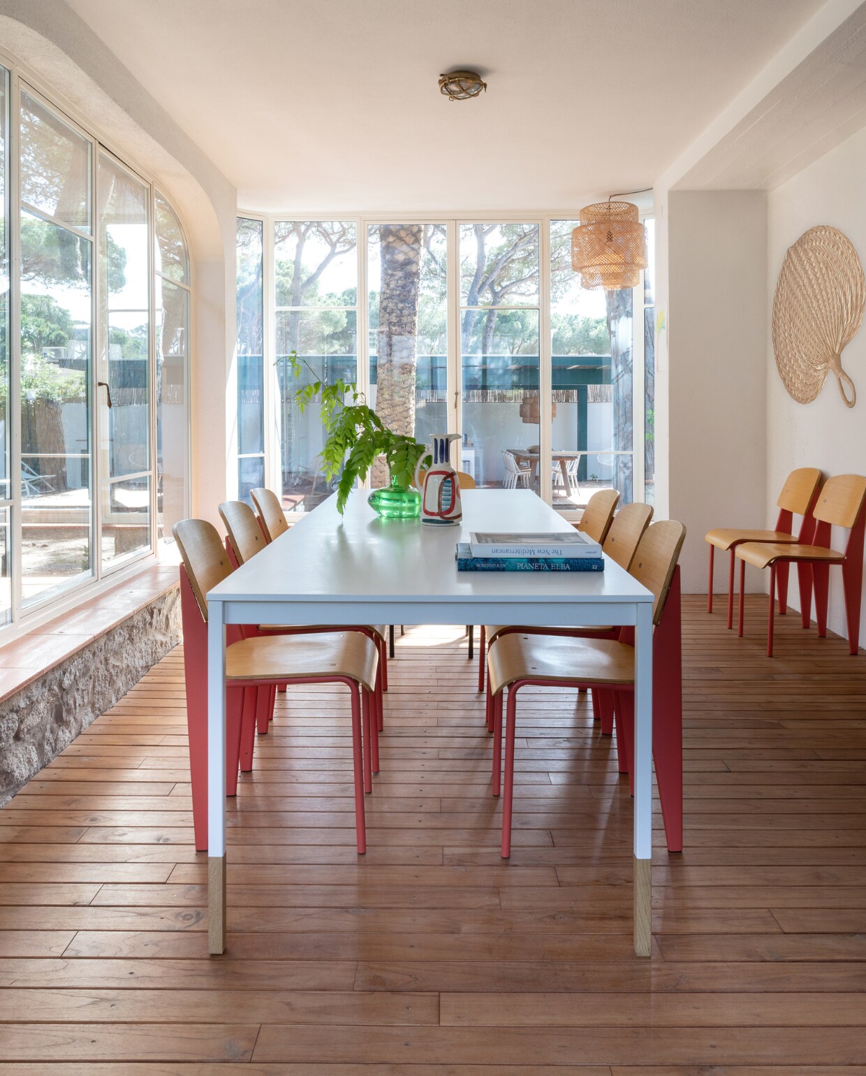 Stoelen Jean Prouvé, keramieken kan LRNCE, aan de wand een vintage waaier, hanglamp Sinnerlig van Ikea. Tafel en glazen vaas onbekend. vtwonen special binnenkijken 06-2023| productie Living Inside | fotografie Monica Spezia