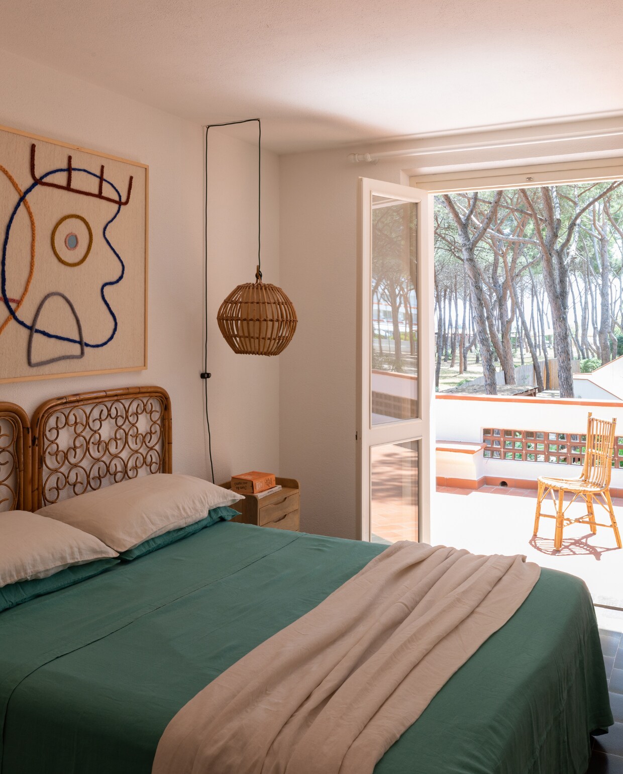 Bamboe hanglamp en hoofdbord waren al aanwezig. Houten nachtkastje Maisons du Monde. Wandkleed LRNCE. Beddengoed Society Limonta. vtwonen special binnenkijken 06-2023| productie Living Inside | fotografie Monica Spezia
