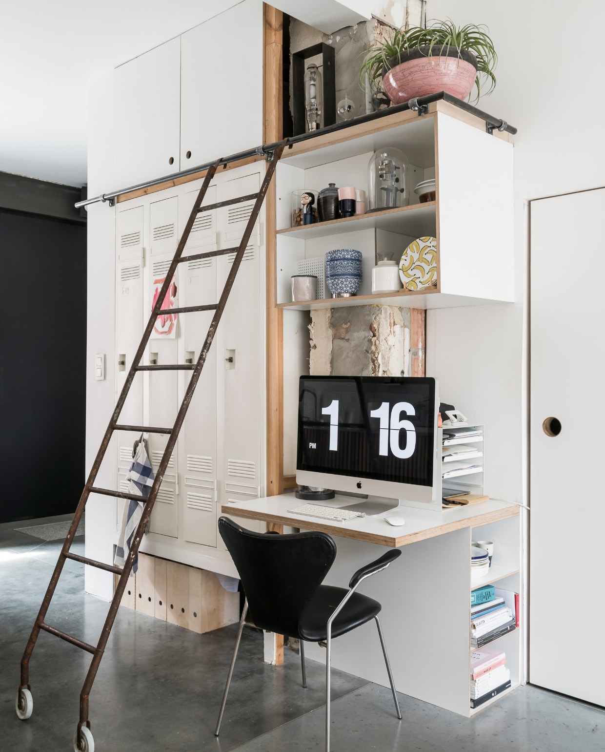 De ladder en ingebouwde lockerkast komen uit de oude verlaten brouwerij van Stella Artois. Op deze foto is duidelijk te zien dat elke vierkante centimeter wordt benut en dat er enorm veel bergruimte is. Zwarte stoel van Arne Jacobsen. vtwonen 2-2020 | Styling en Fotografie Jonah Samyn |