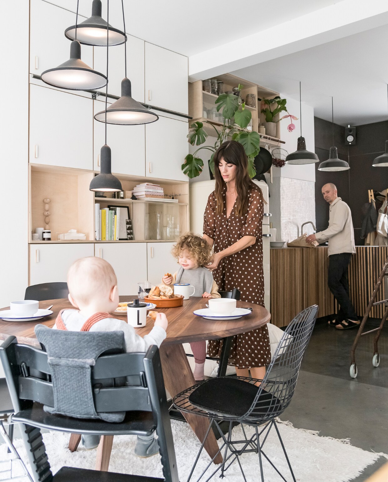 De tafel in Amerikaanse notelaar, keuken en inbouwkast zijn door William gemaakt. Wire Chair van Eames voor Vitra, Tripp Trapp stoel van Stokke. Lampen boven tafel Torch Light van Established &amp; Sons. Vloerkleed Jinzu. vtwonen 2-2020 | Styling en Fotografie Jonah Samyn