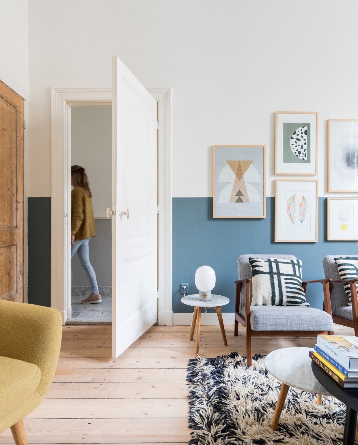 Lambriseringen in kleur Metamorfose Histor, originele houten vloer opnieuw gebeitst, ingelijste prints Stilleben, armstoelen Ikea, kussens  Ferm Living, bijzettafeltje en salontafel Zuiver, lamp Menu, kleed HK Living. Overig privébezit. vtwonen 08-2018 | styling Sabine Burkunk | fotografie Hans Mossel