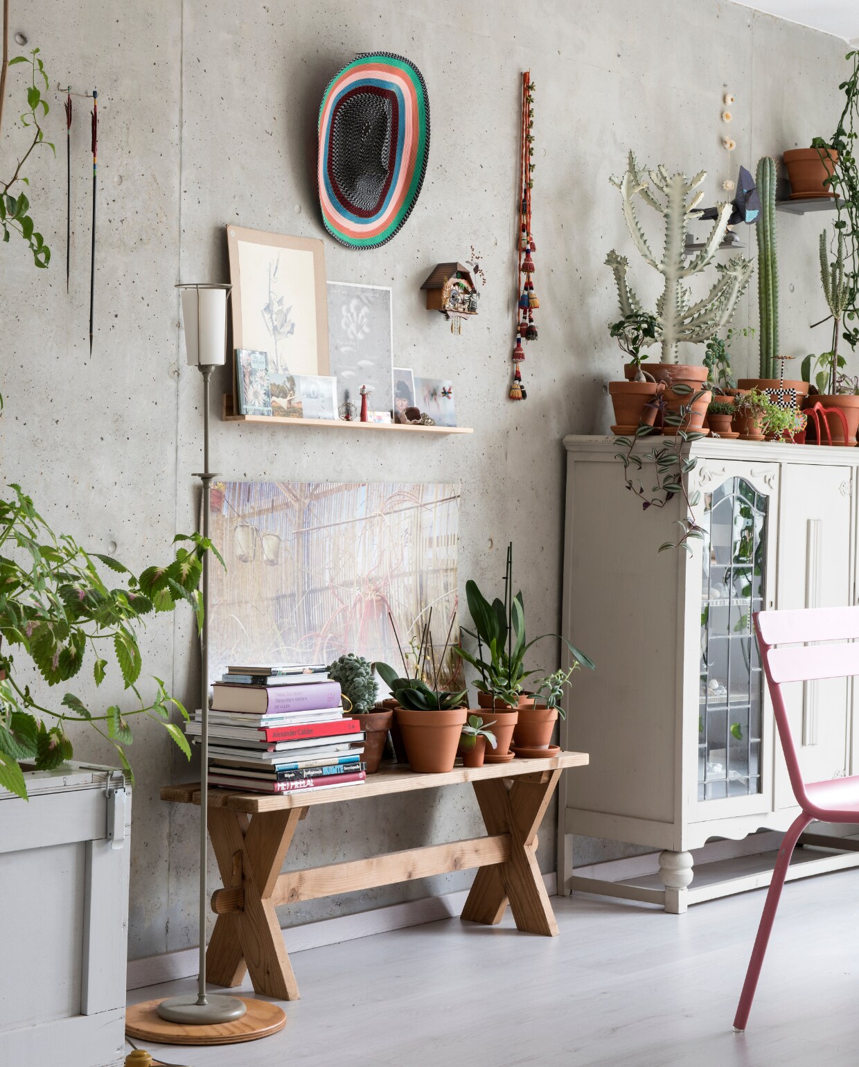 De betonnen muur hebben ze zo gelaten. De kist is een ontwerp van Vladi, de twee pijlen tweedehands winkel Amsterdam. Staande lamp rommelmarkt. Plankje met kaarten gemaakt door Vladi. Zelfgemaakte foto van de Botanische Tuin in Tel Aviv. Masker aan de muur Bertjan Pot. Klokje gekocht in Oostenrijk, stoffen kralenslinger uit Istanbul. De kast hebben Anne en Vladi gekregen. Het verlichtingssnoer was een cadeau. Overig onbekend. vtwonen 07-2017 | styling Esther Jostmeijer | fotografie Louis Lemaire/Inside Homepage