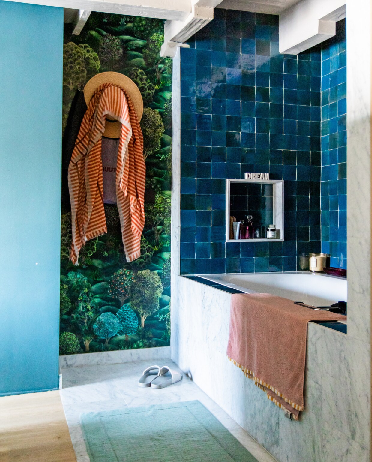 Badkamer op maat gemaakt naar ontwerp van Femkeido. Tegels Designtegels, behang Cole &amp; Son, bad Sanidump, badmat Merci, handdoek Sissy-Boy. Muurverf Inchyra Blue van Farrow &amp; Ball. Overig onbekend. vtwonen 10-2023 | productie CocoFeatures | fotografie Laura Emma van Geest