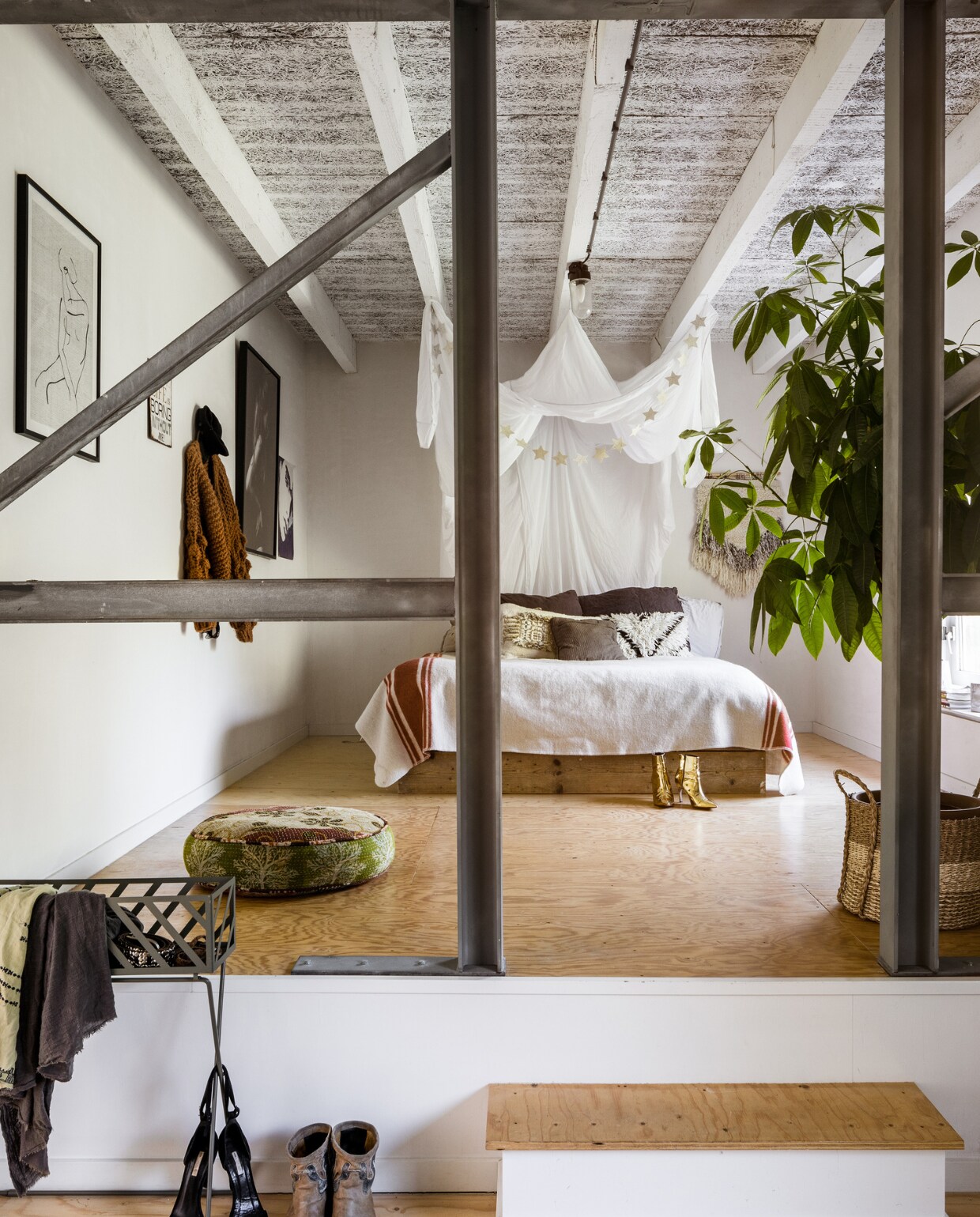 De masterbedroom met een bed van Jorg steigerhout. De deken is van Piet Hein Eek, de klamboe werd online besteld. Sterretjes decoratie van NAdesign, poef Evenaar Eigenwijs wonen, print vooraan van HK Living via Mariekes shop. Vloer van underlayment platen. vtwonen 09-2019 | styling Sabine Burkunk, Buro Binnenhuis | fotografie Hans Mossel