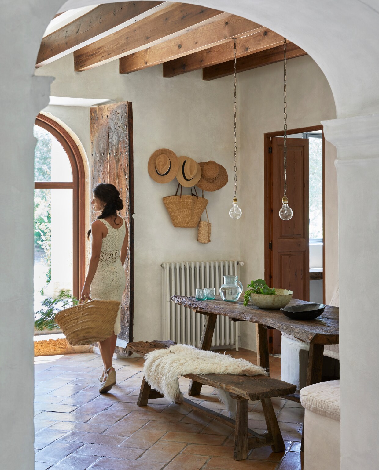 Hoeden, manden en glaswerk lokaal gekocht. Tafel lokaal gemaakt van oude eiken wijnvaten. Hanglampen zelfgemaakt. Keramiek uit eigen atelier. Schapenvacht via hun eigen bedrijf Terra Coll Home afkomstig van een Ierse boerderij. vtwonen special binnenkkijken 06-2023 | productie Bureaux/Living Inside | fotografie Greg Cox