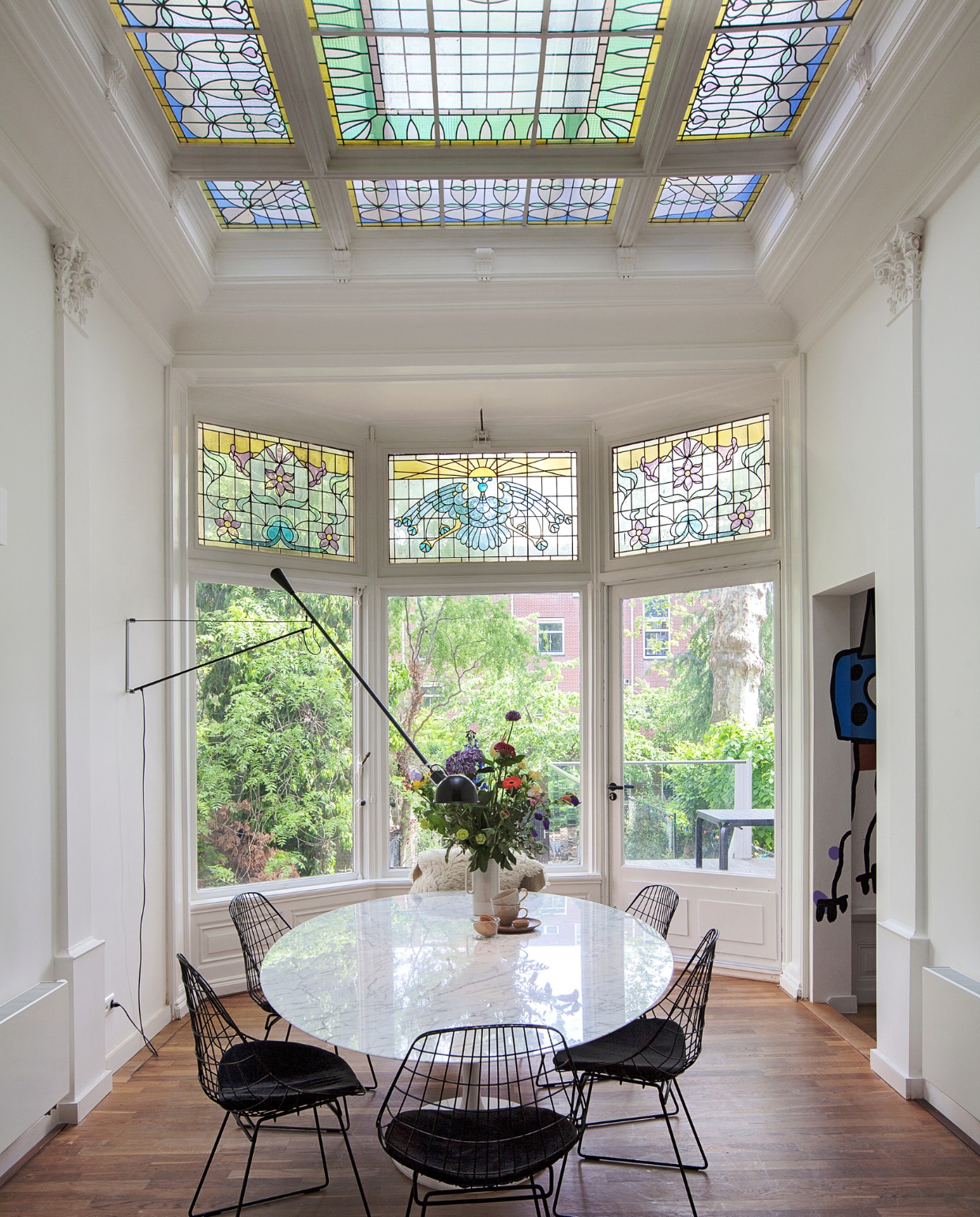 Tafel met marmeren blad Eero Saarinen voor Knoll, draadstaalstoelen SM05 van Cees Braakman voor Pastoe, vacht van de biologische Nieuwmarkt in Amsterdam. Wandlamp 265 van Flos. Kop en schotels Kieveen. Overig onbekend. vtwonen special binnenkijker 121-2020 | fotografie Corine Hoge Bavel | styling Sheila Sletbeen via Kieveen