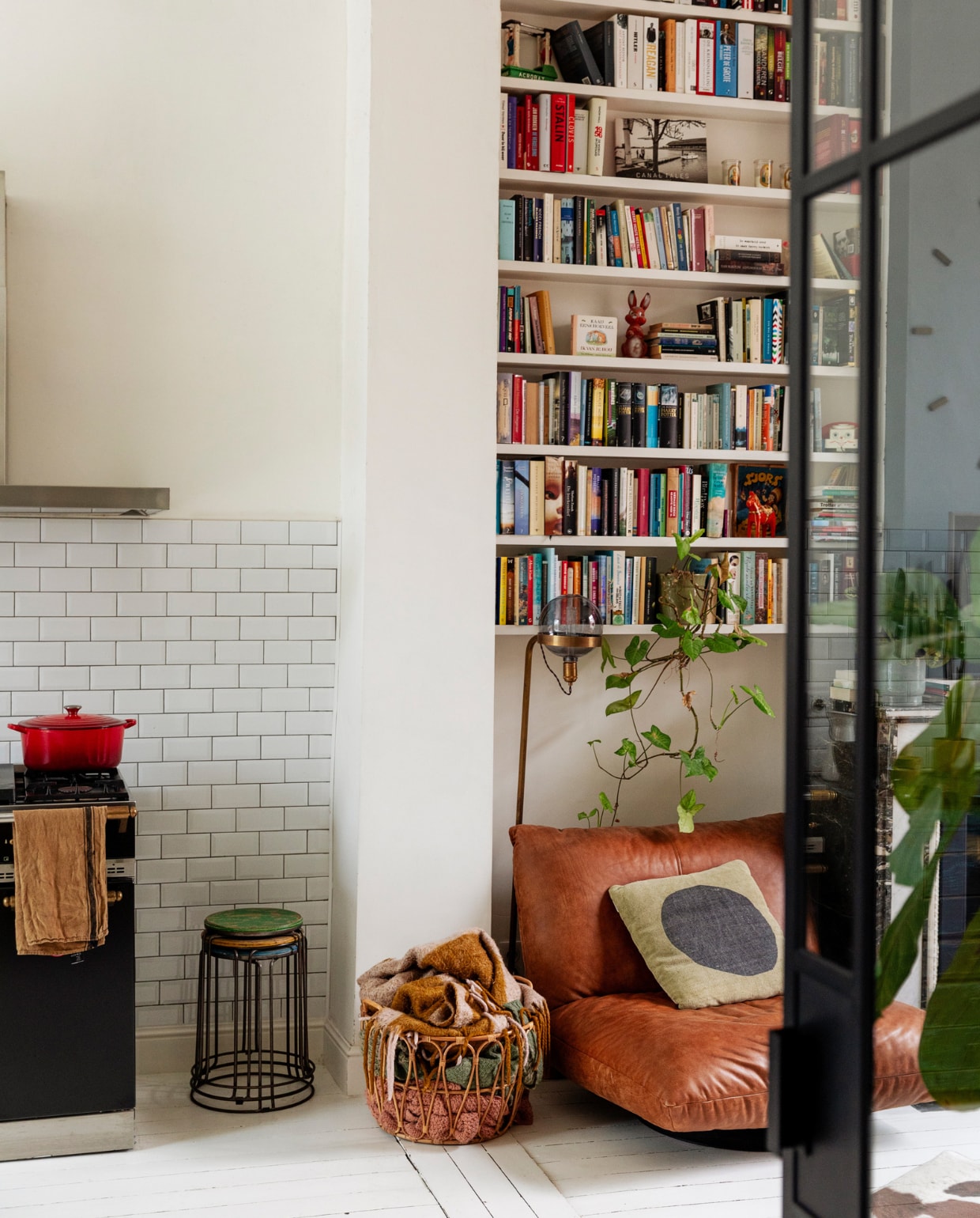 Metrotegels Impermo, pan Le Creuset. Keuken/oude schroefbank, vloerlamp, scheepsfauteuil en krukken Woontheater. Mand Ikea, vloerkleed koevel van de markt. Overig onbekend. vtwonen 10-2023 | styling Ilona Jongepier | fotografie Dana van Leeuwen